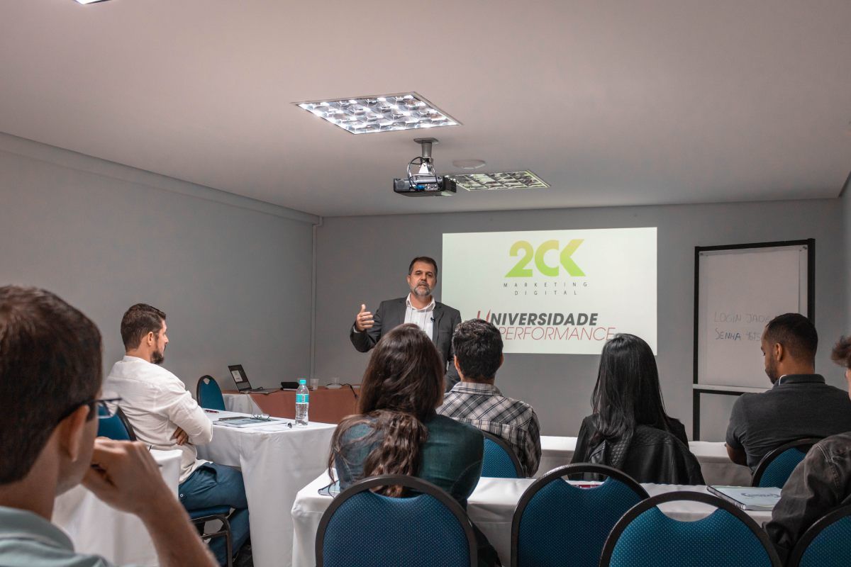 Um homem está fazendo uma apresentação para um grupo de pessoas em uma sala de conferências.