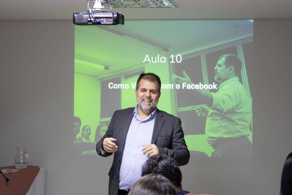 Um homem de terno está fazendo uma apresentação para um grupo de pessoas.