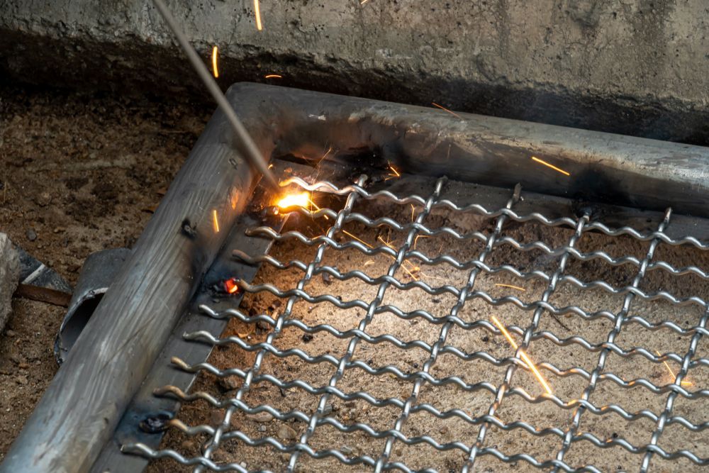 Welder Fusing Metal Mesh to a Metal Frame — Bryants Laser Works in Somerset & Lockyer Valley, QLD