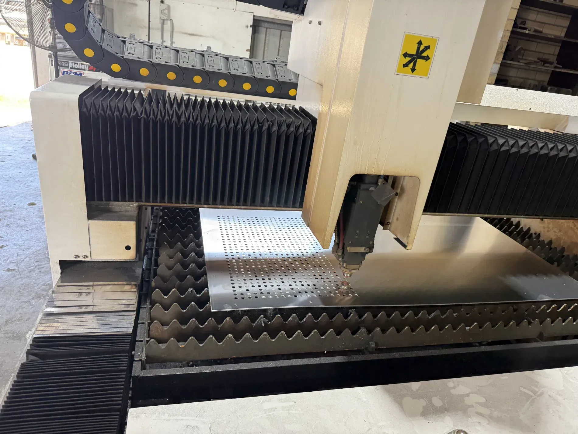 Laser cutter in action, cutting sheet metal with sparks in a factory setting — Bryants Laser Works in Ipswich, QLD