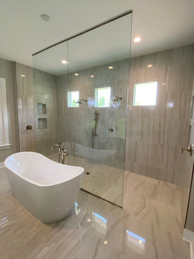 Modern bathroom with a freestanding tub, glass shower, and tiled walls and floor.