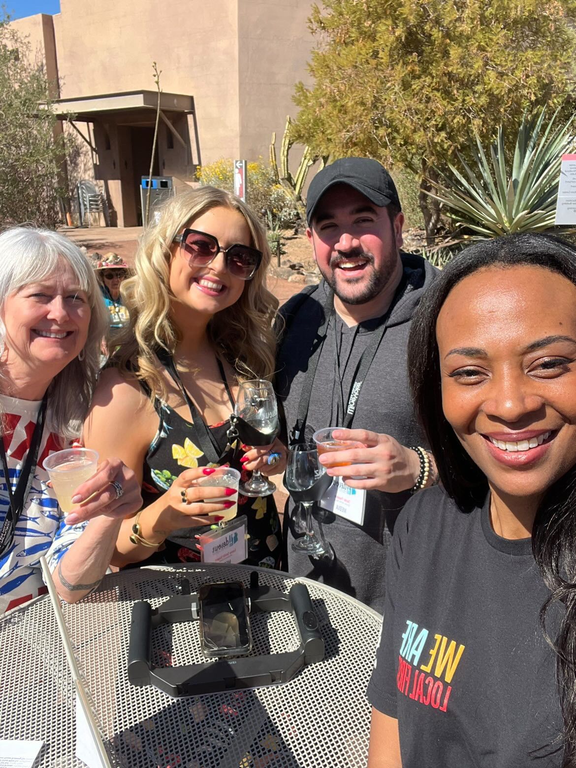 A group of people are posing for a picture while holding drinks.