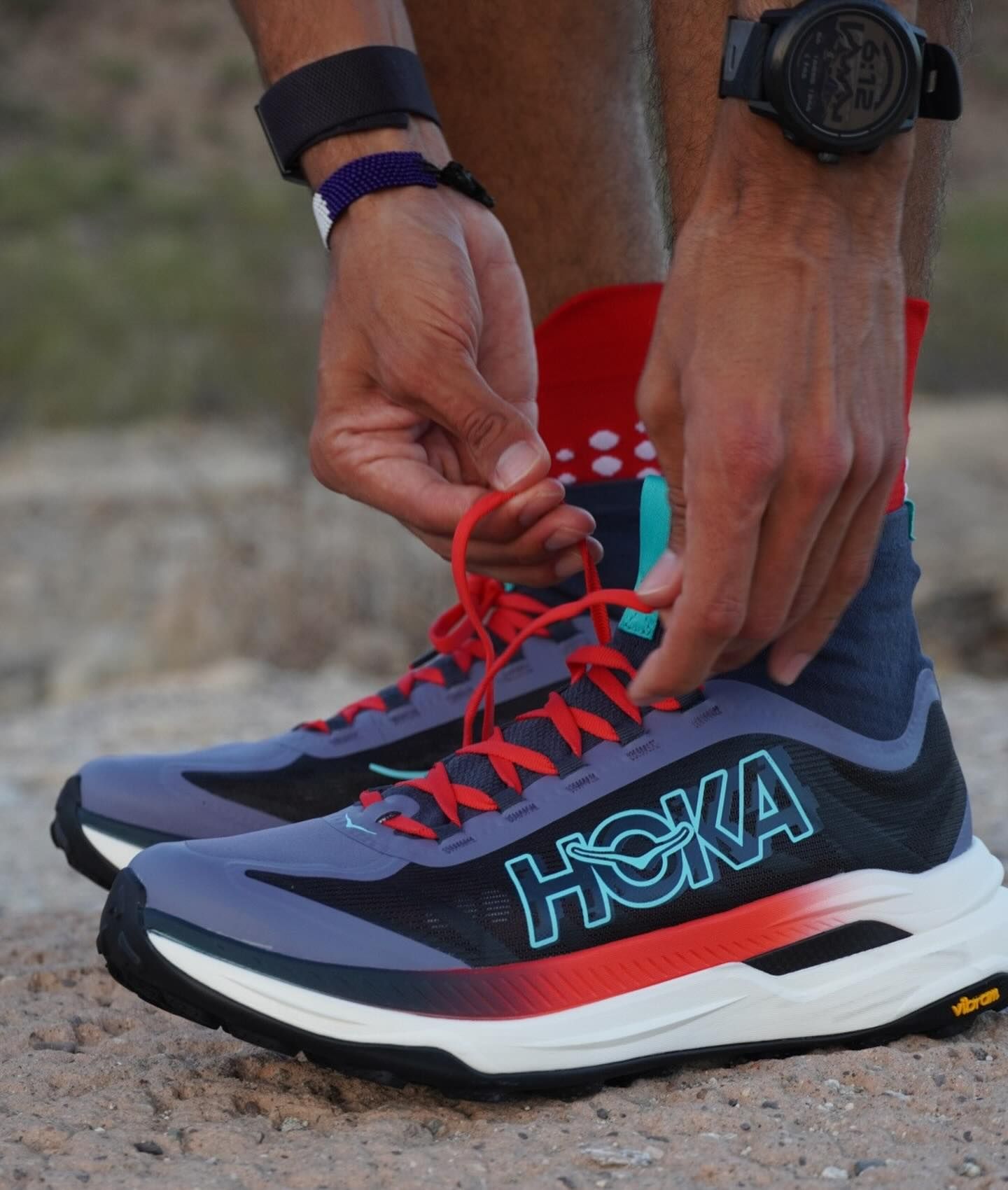A person is tying a pair of hoka shoes