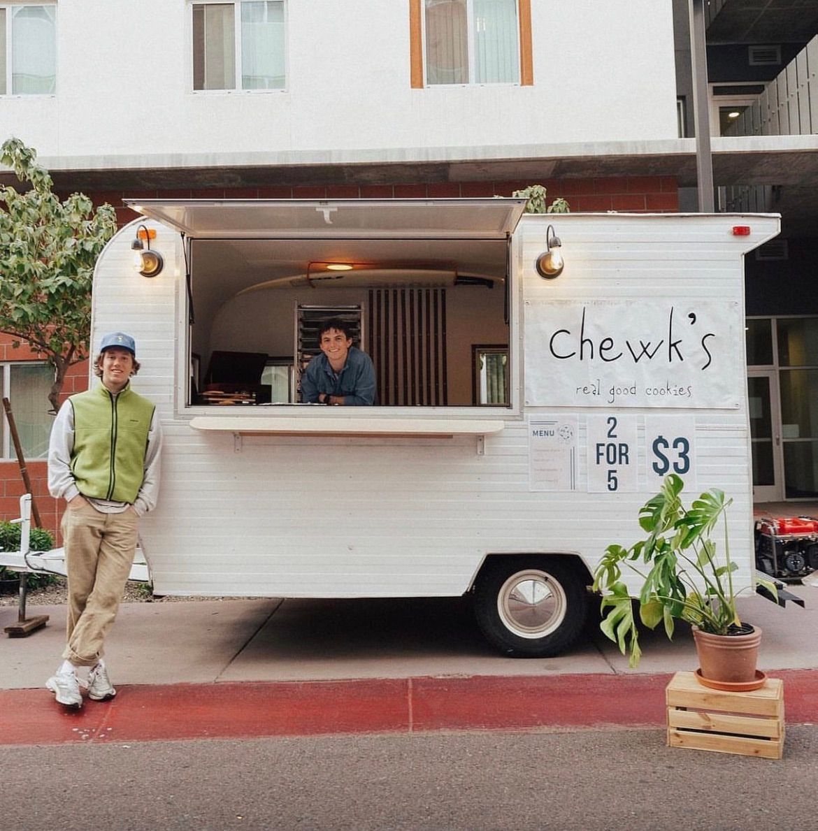 A man stands in front of a chew 's food truck