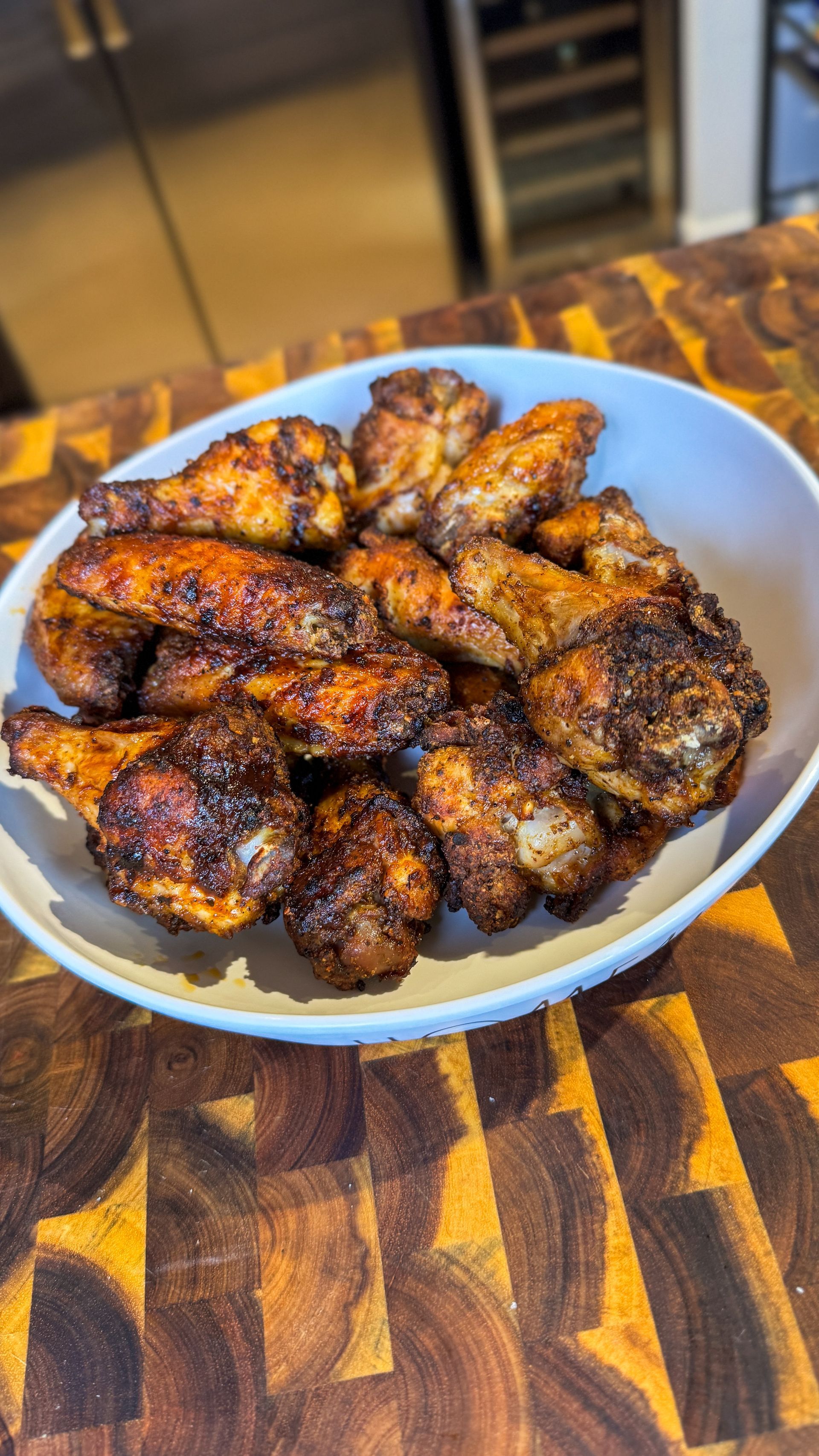Man holding a tray of loaded nachos, brown cabinets in background, excited expression.