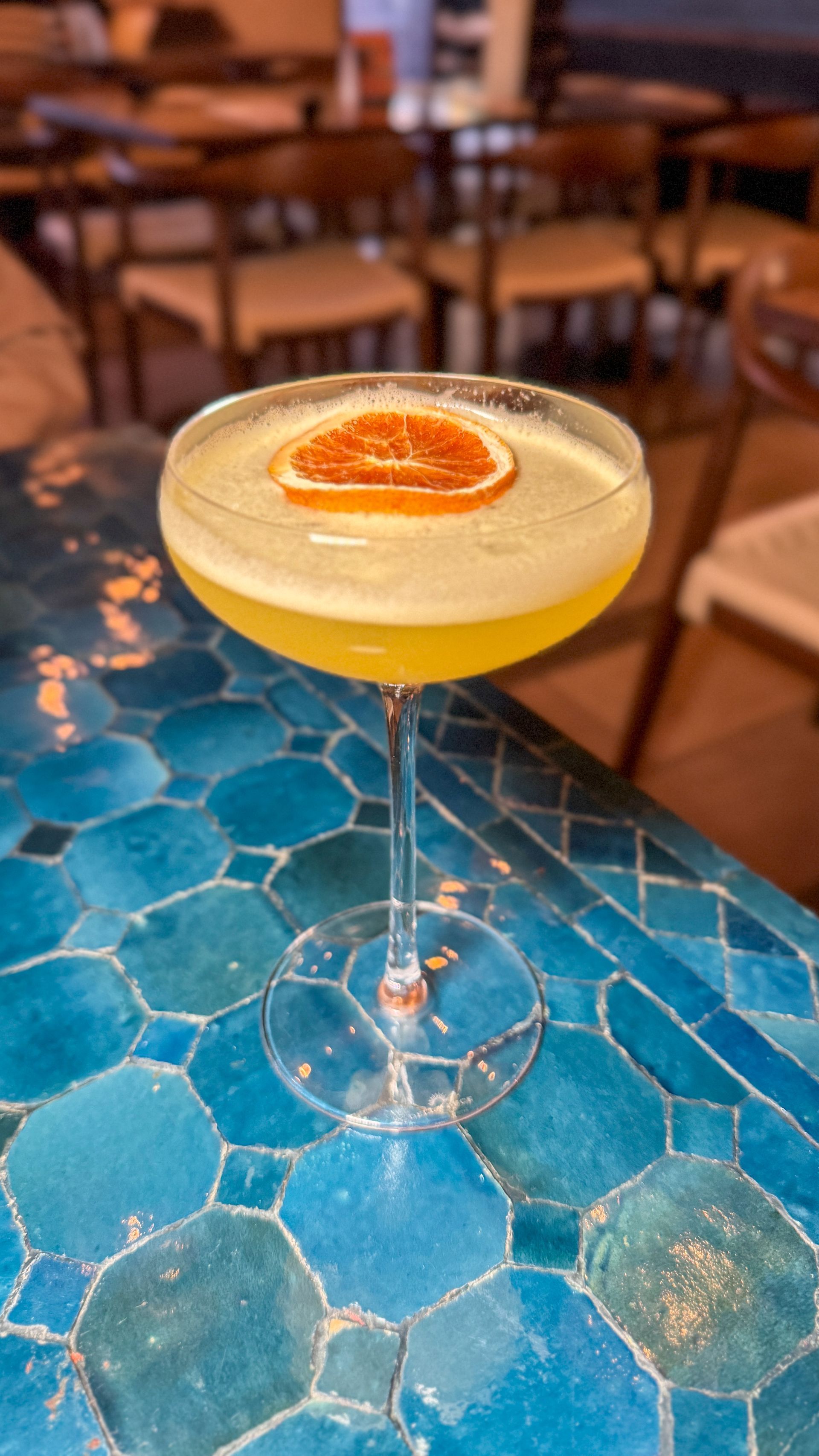 A close up of a cocktail in a martini glass on a table.