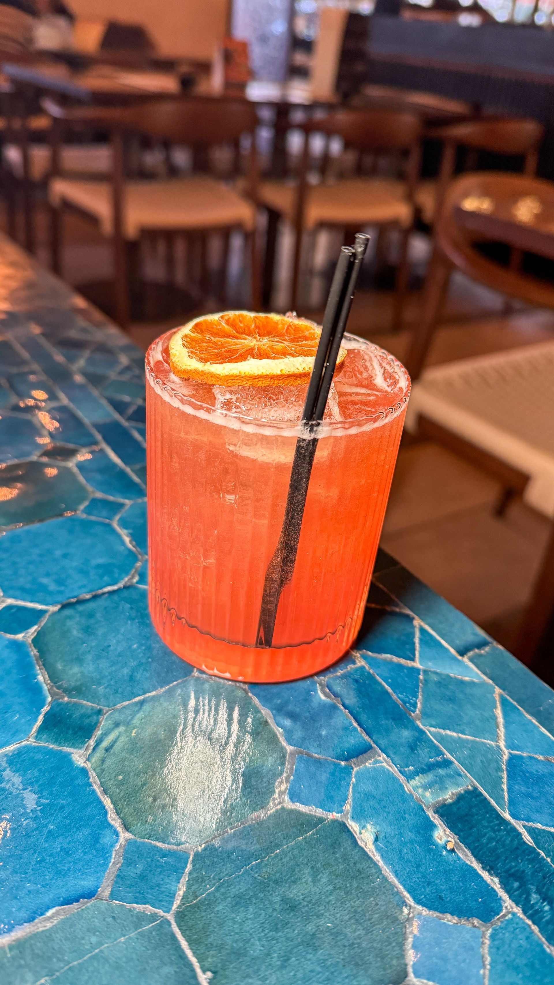 A close up of a drink with a straw on a table.