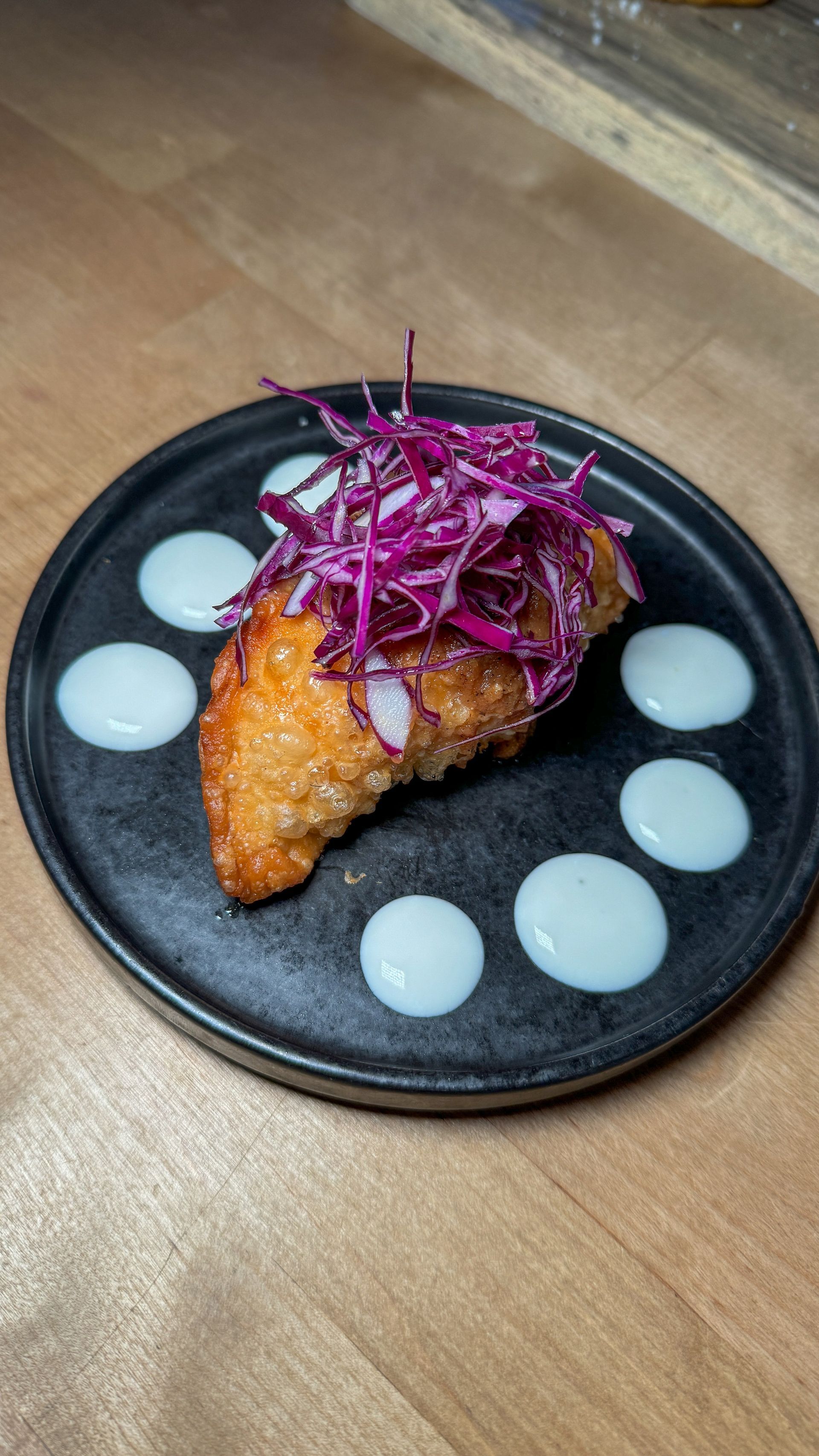 A close up of a plate of food on a wooden table.