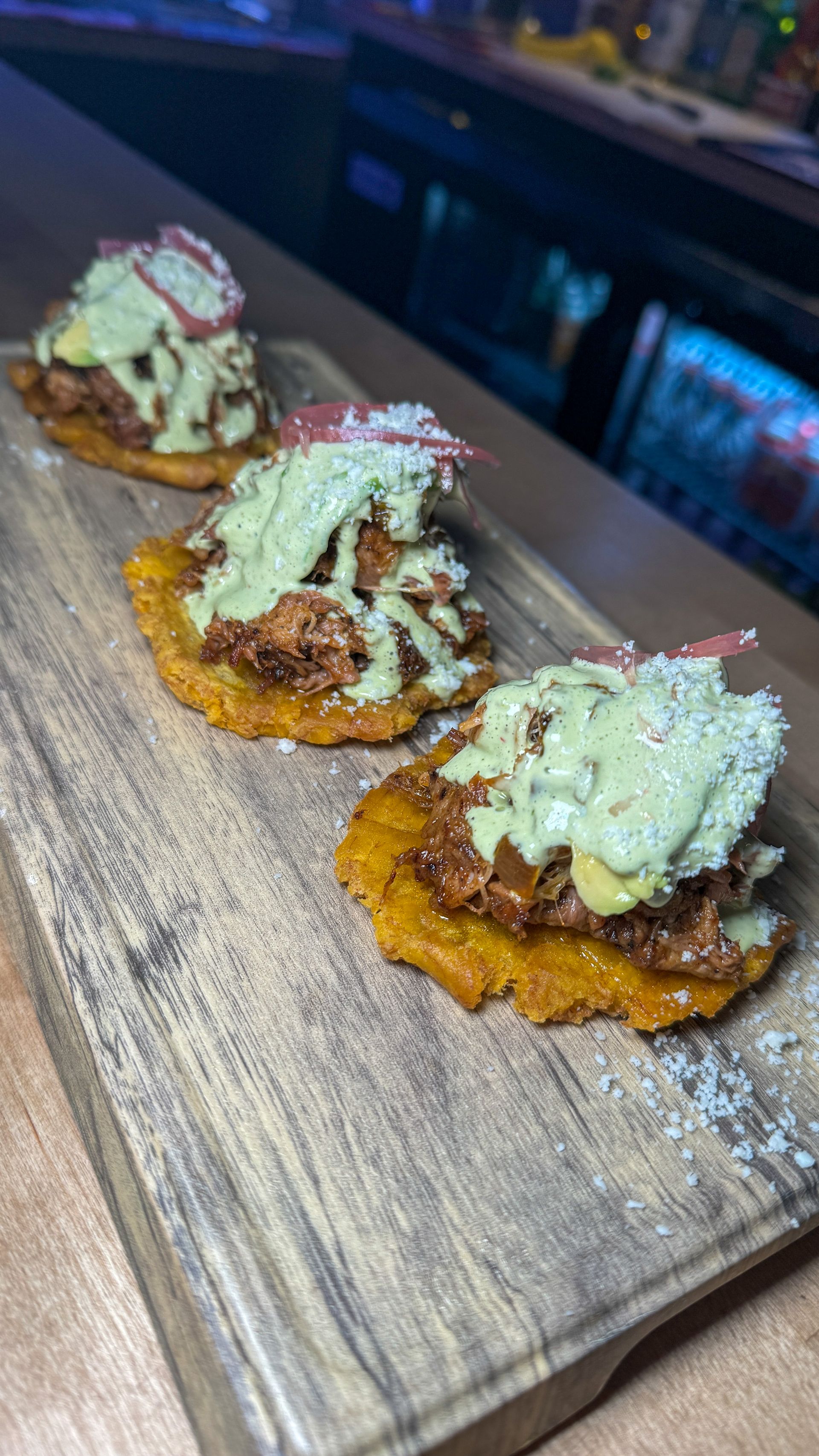 A wooden cutting board topped with three pieces of food.