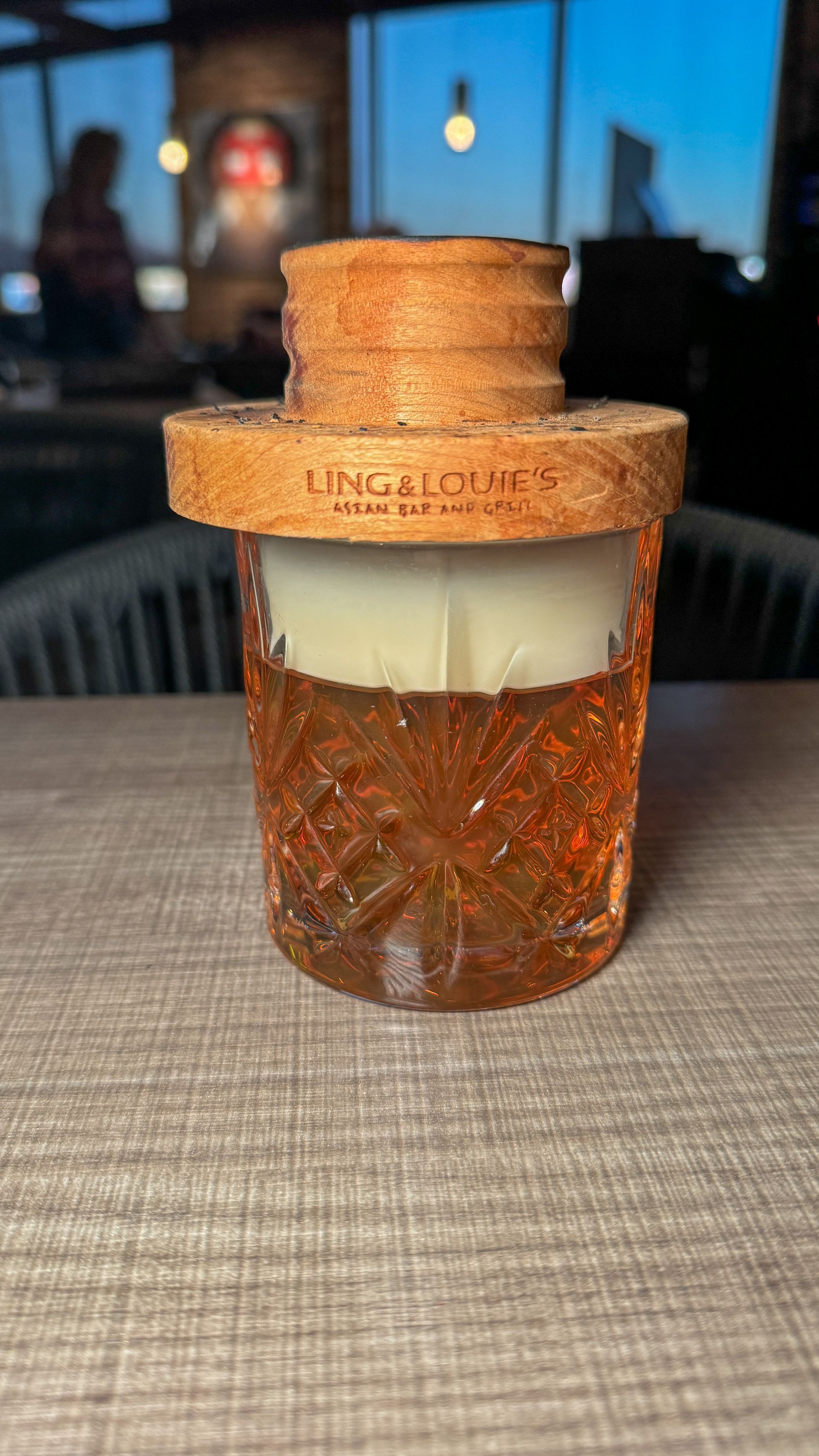 A glass bottle with a cork lid is sitting on a table.