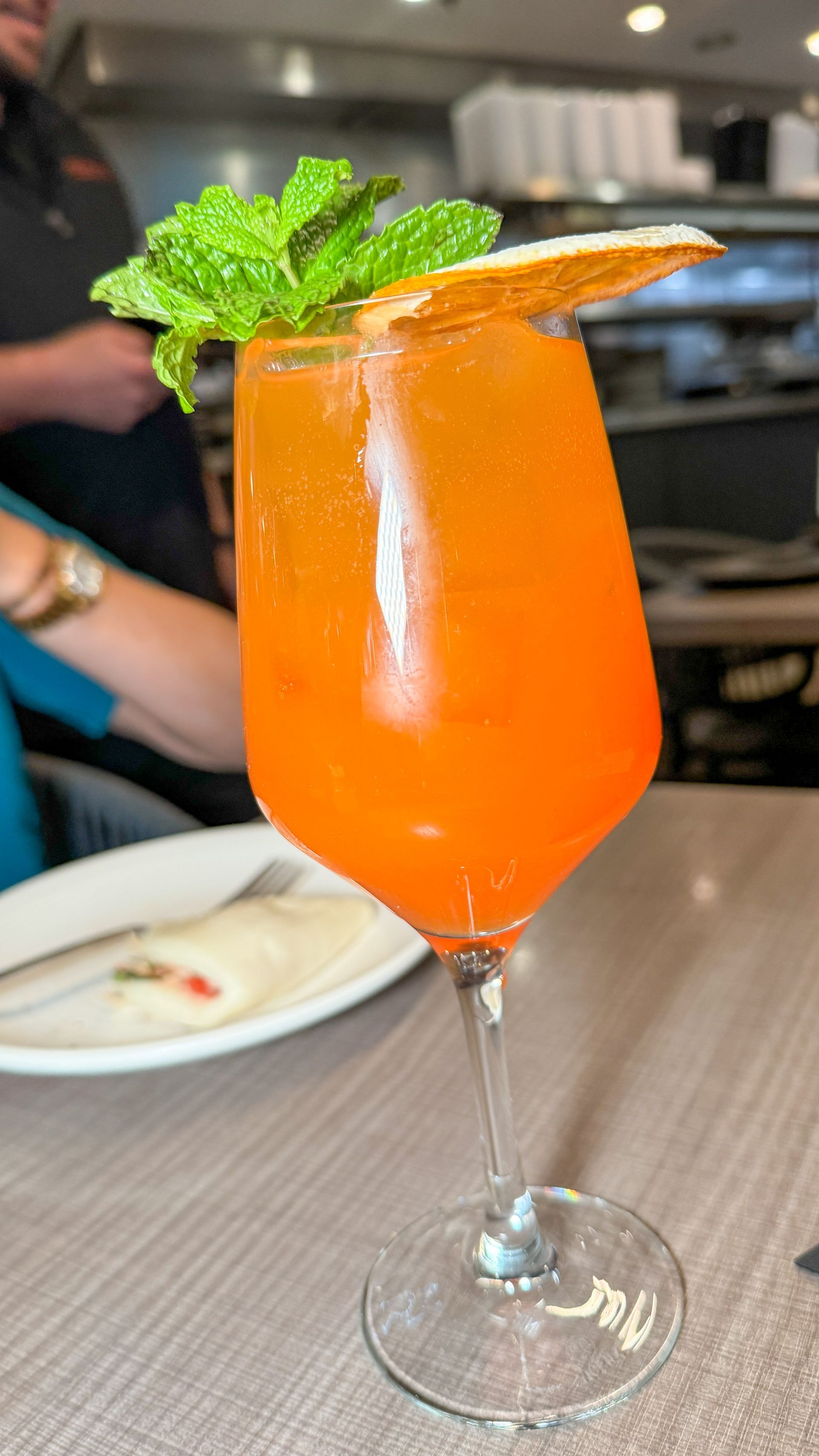 A close up of a drink in a wine glass on a table.