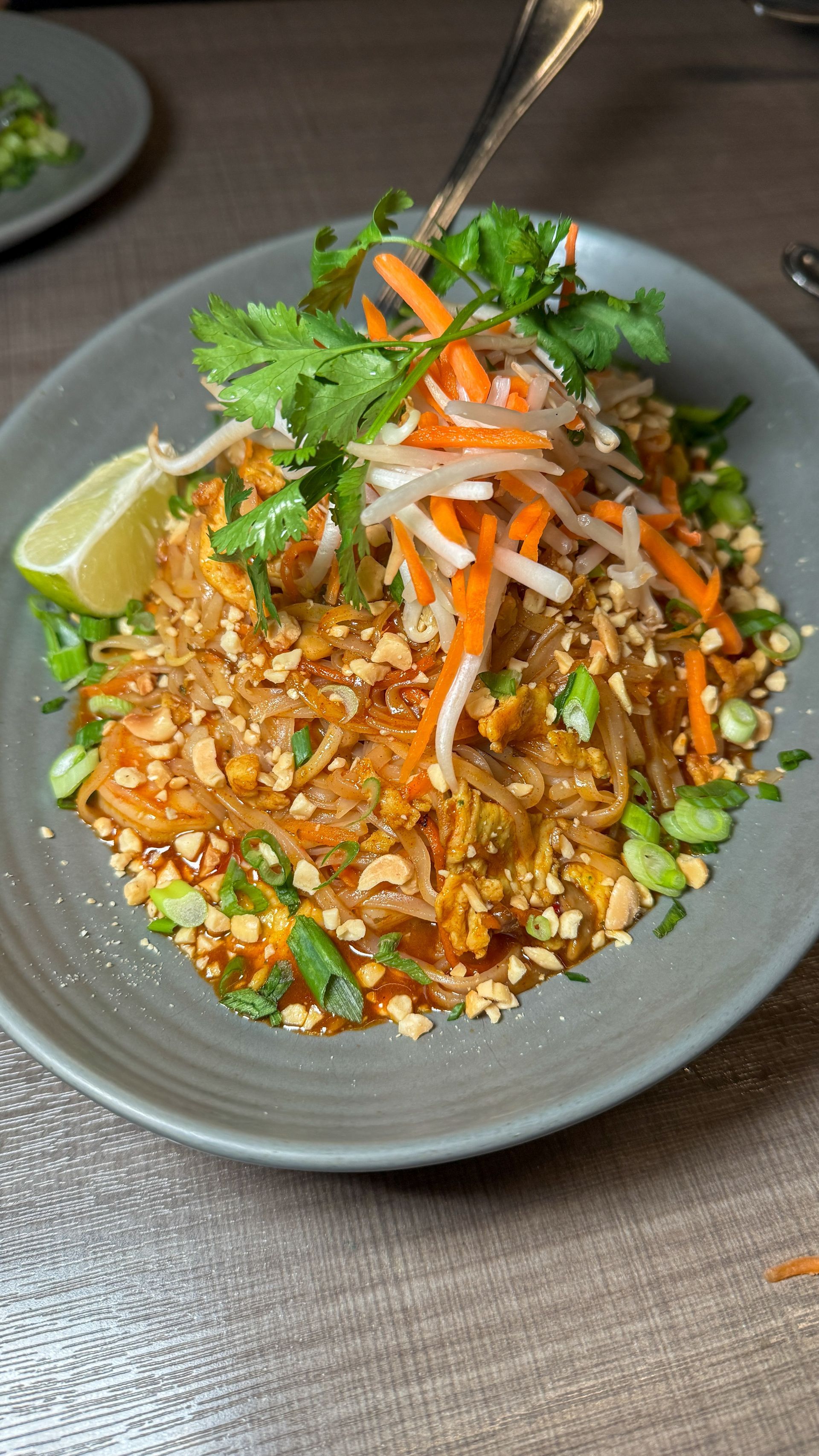 A close up of a plate of food with a fork on a table.