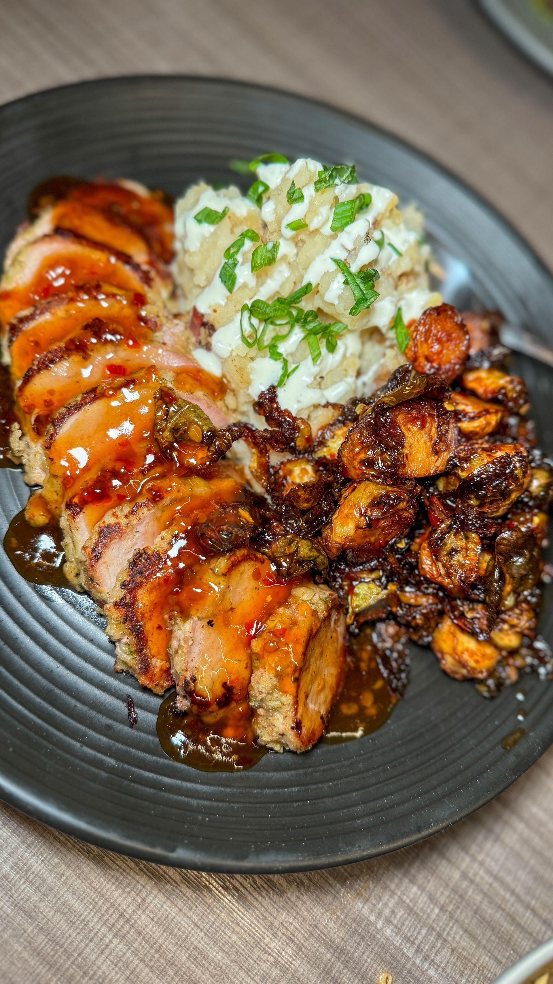 A close up of a plate of food with meat and rice on a table.