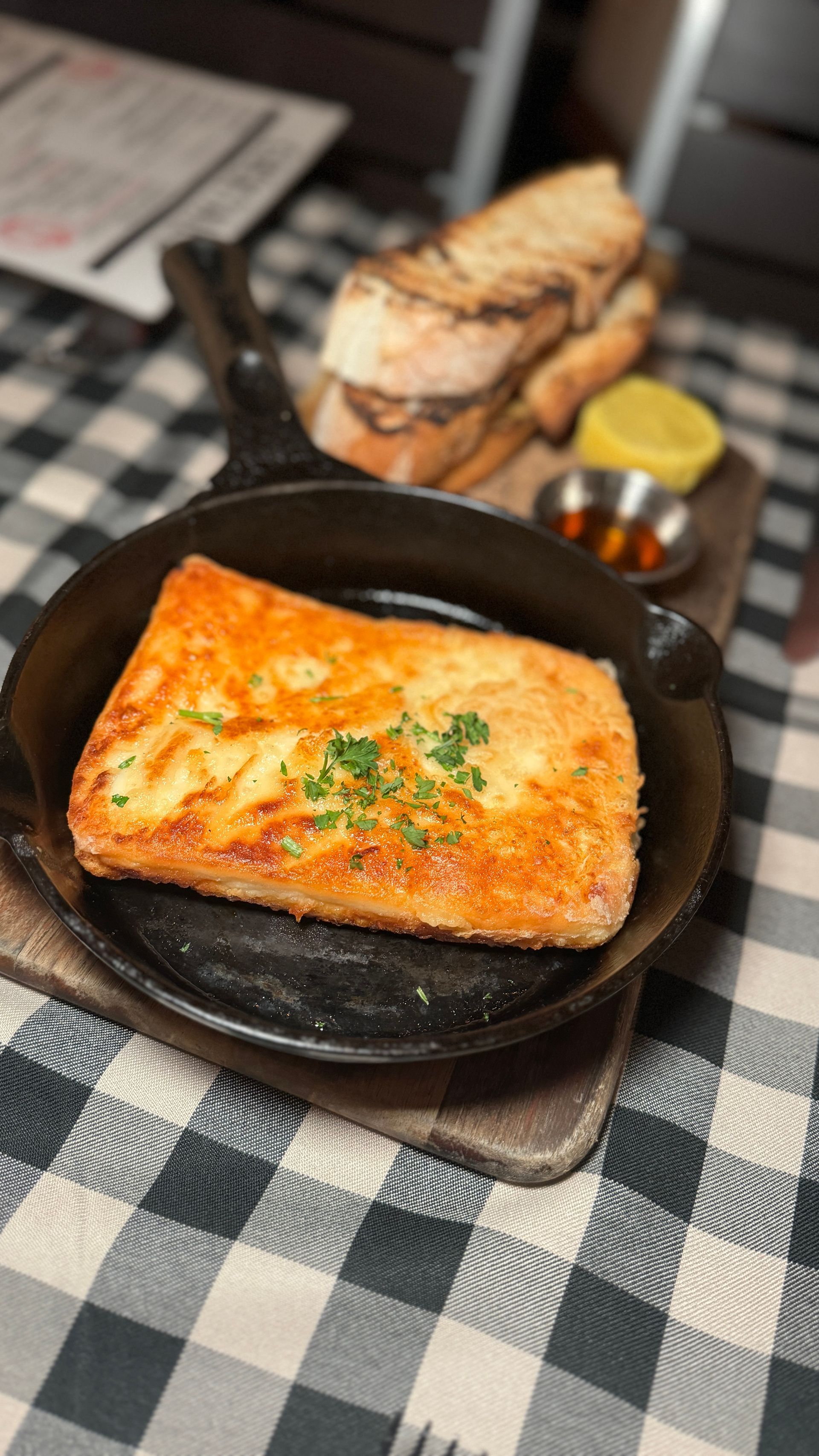 A piece of cheese is sitting on top of a pan on a table.