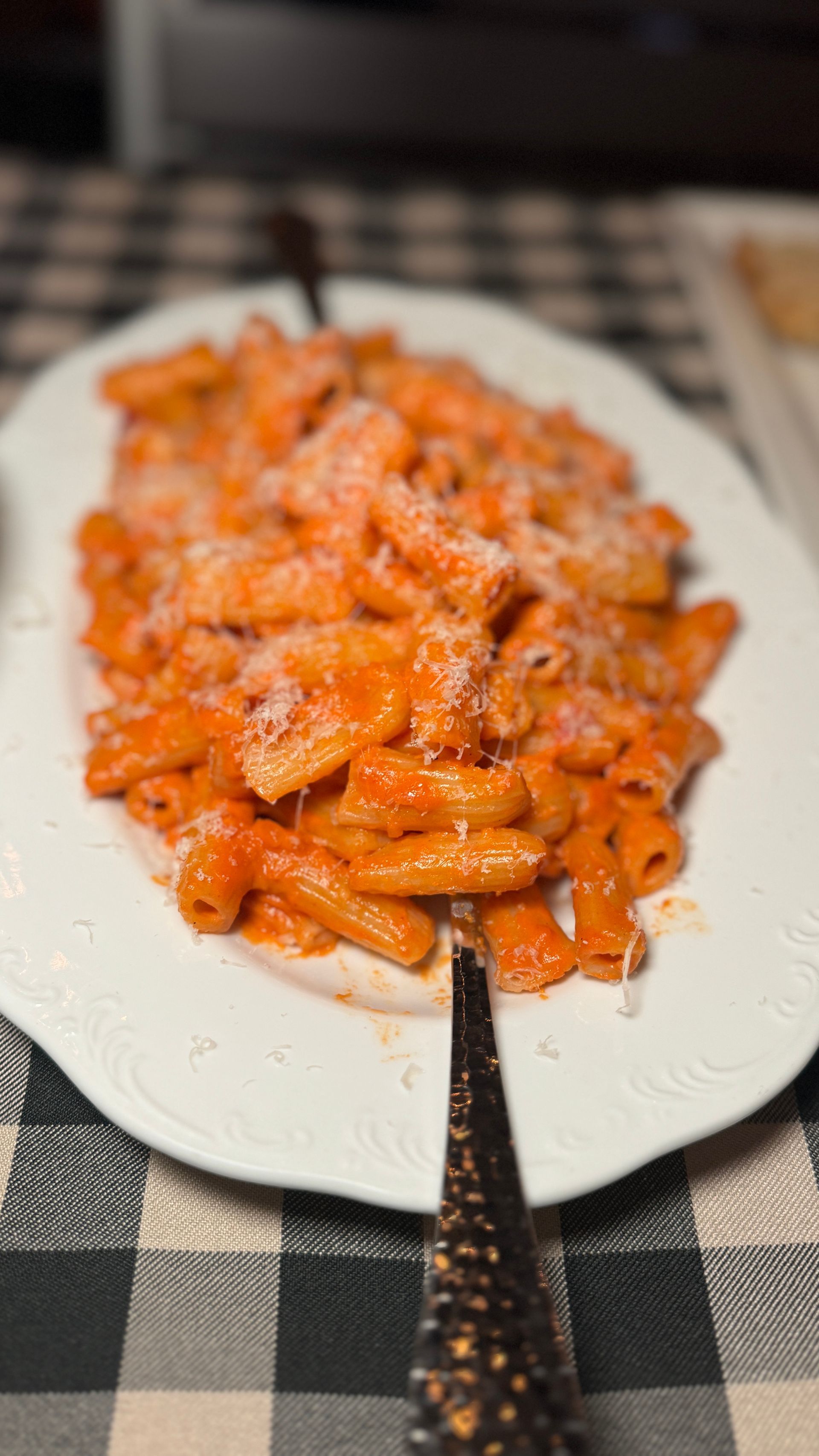 A white plate topped with pasta and sauce on a table.