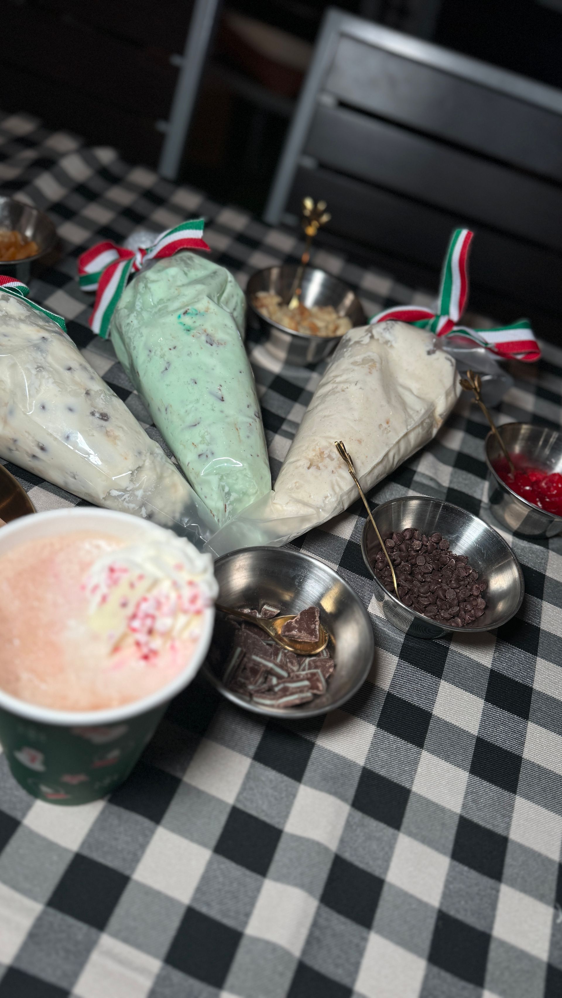 A table topped with ice cream cones and bowls of toppings.