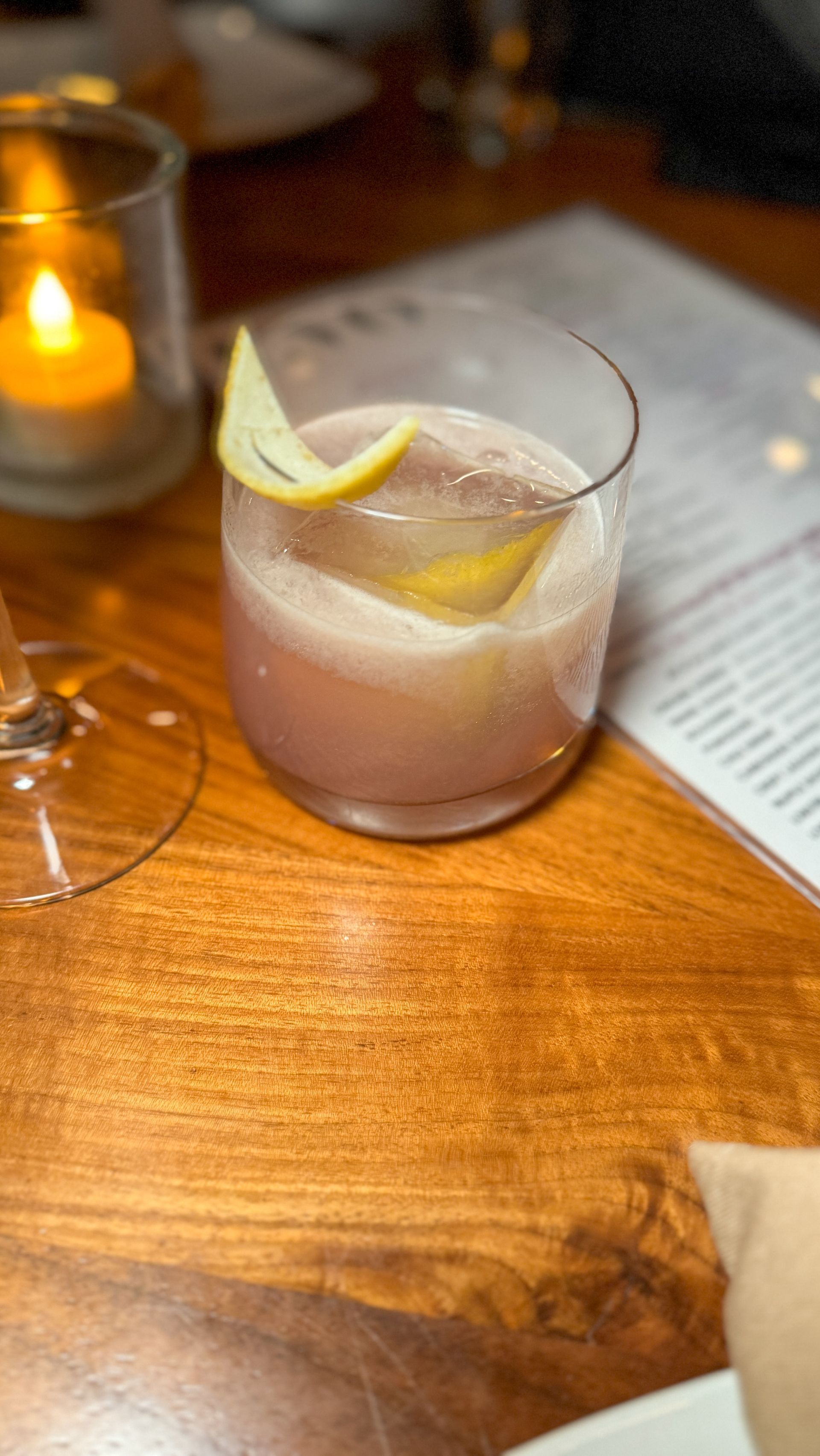 A close up of a drink on a wooden table.