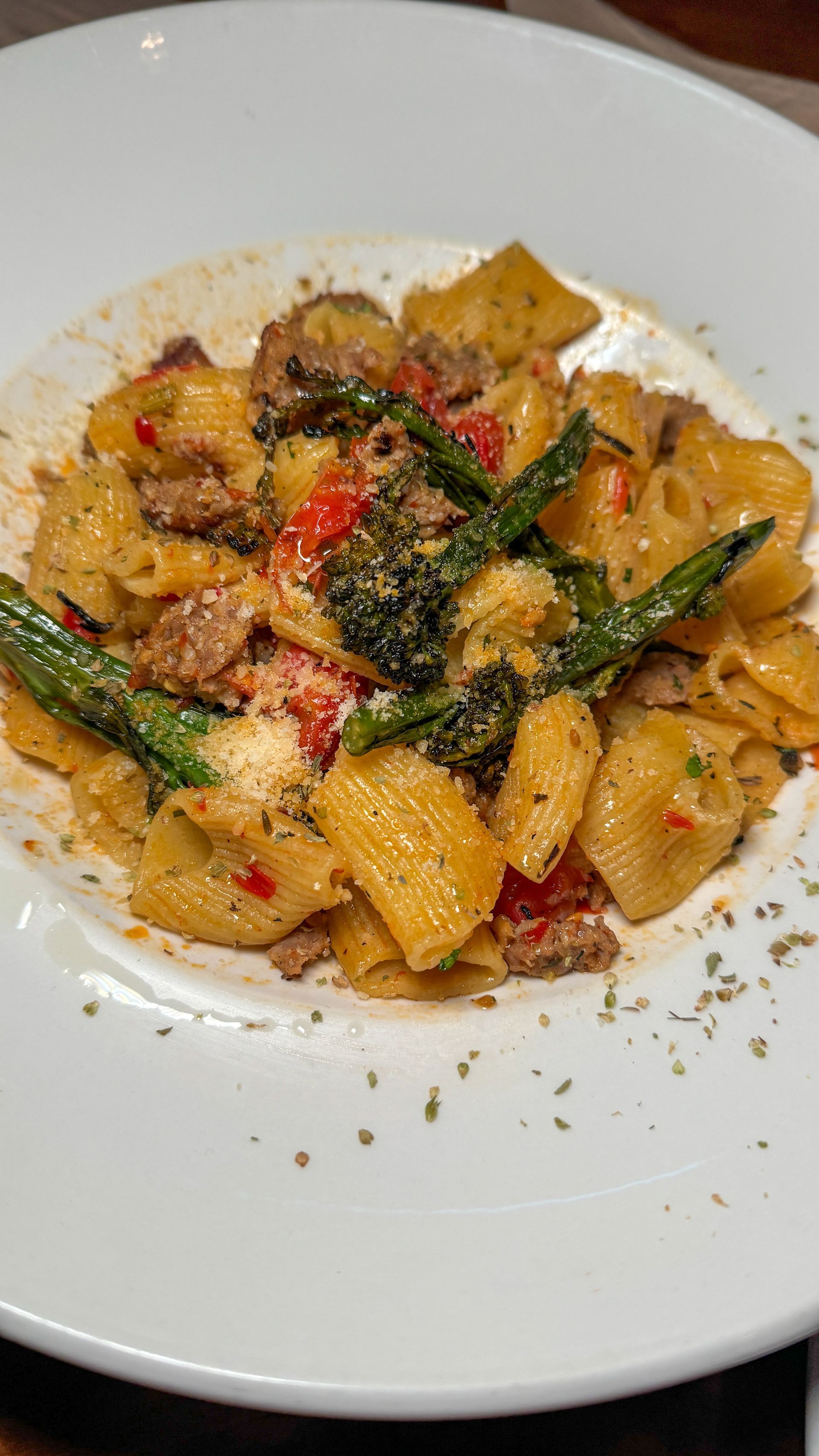 A white plate topped with pasta and vegetables on a table.