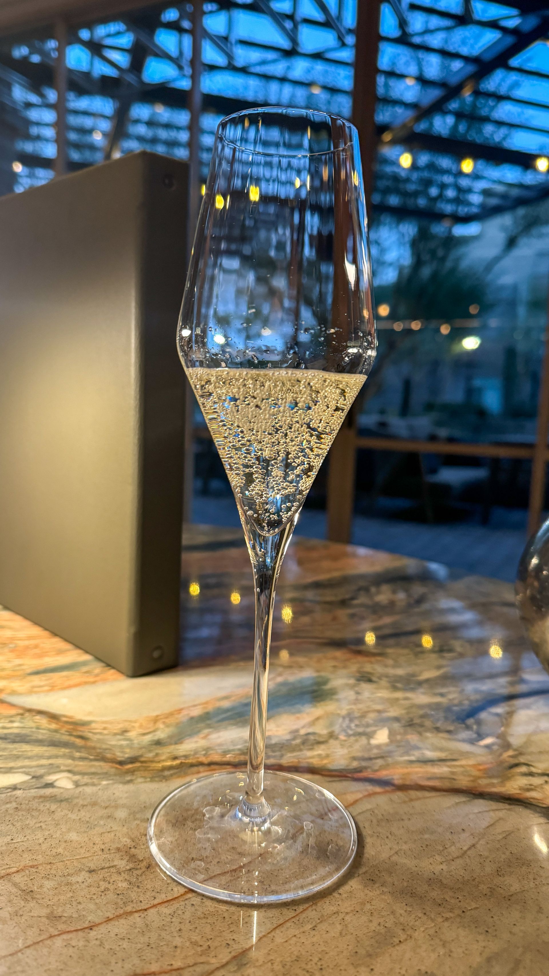 A glass of champagne is sitting on a table.