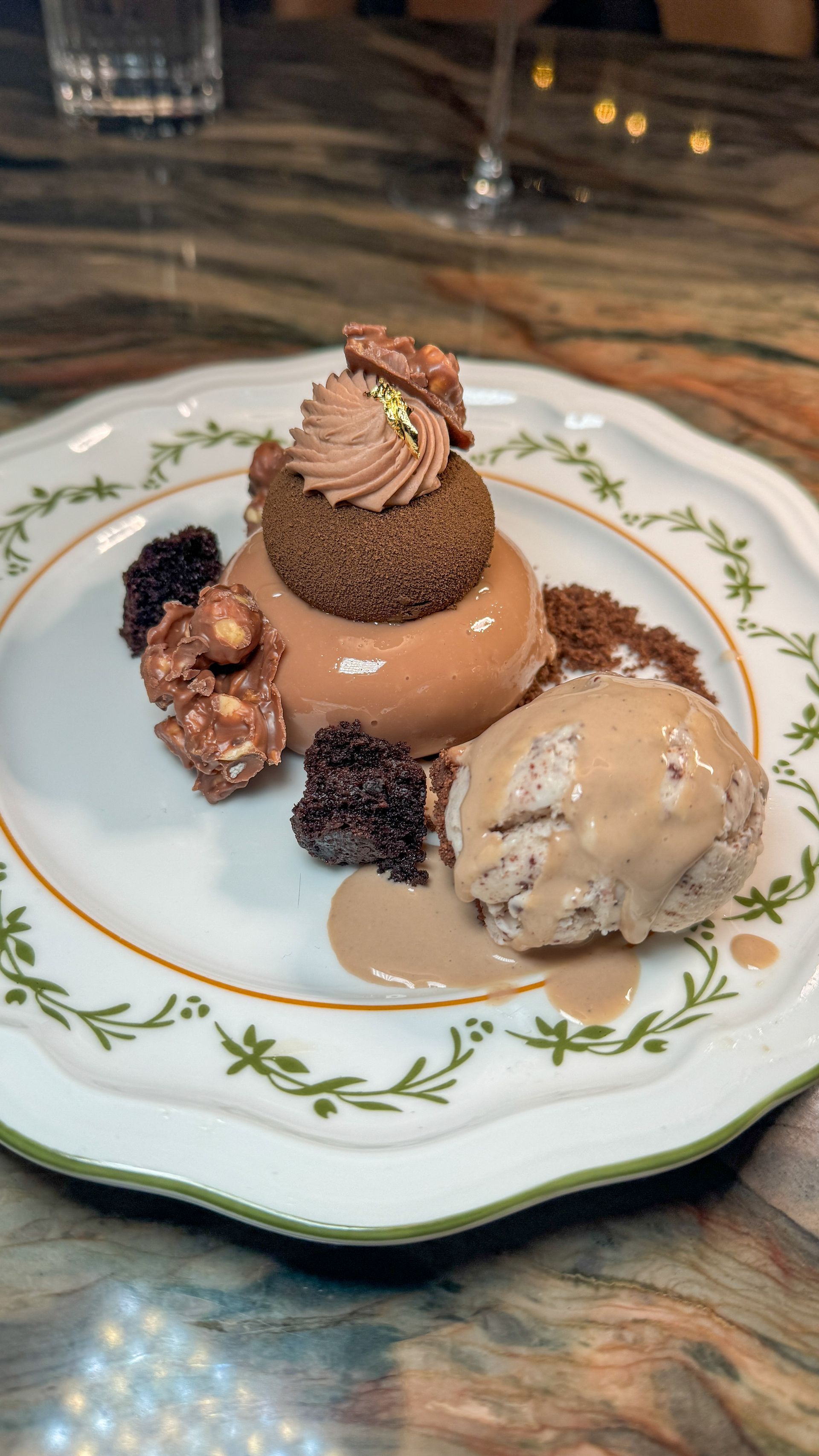 A white plate topped with a dessert and ice cream on a wooden table.