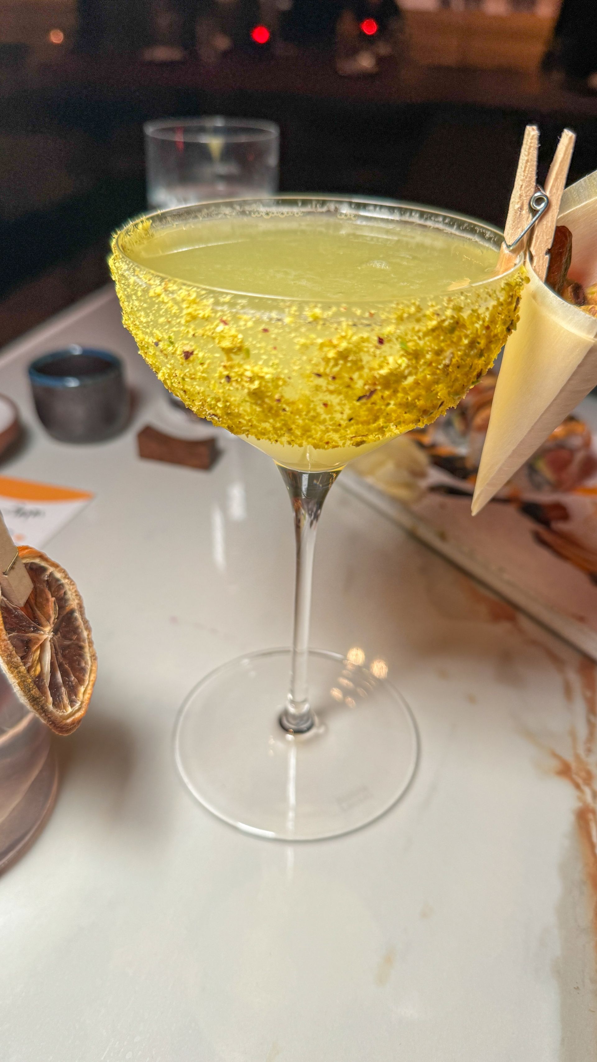 A close up of a cocktail in a martini glass on a table.