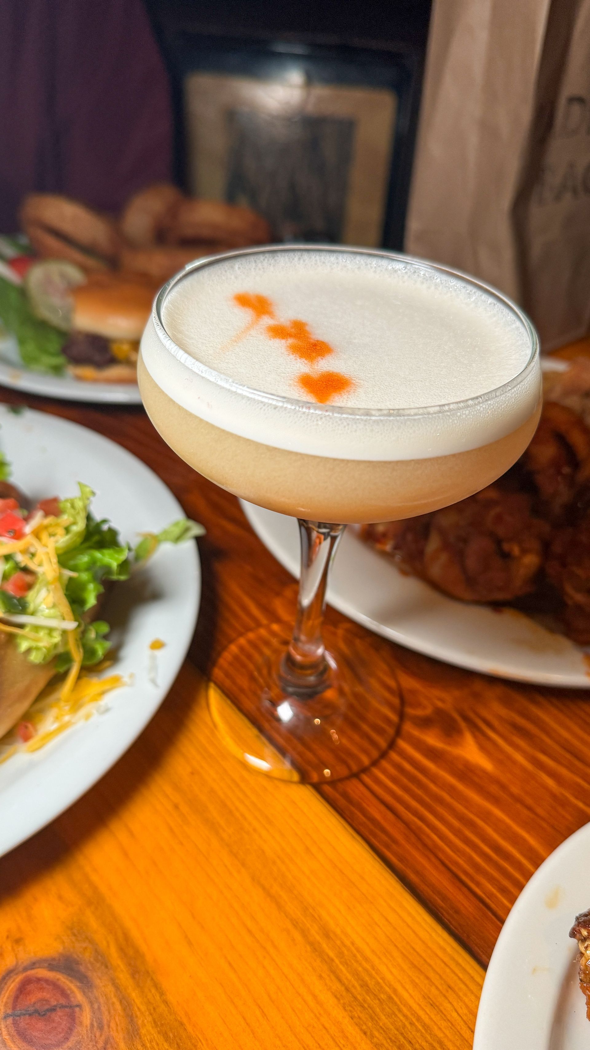 A close up of a cocktail in a martini glass on a table.