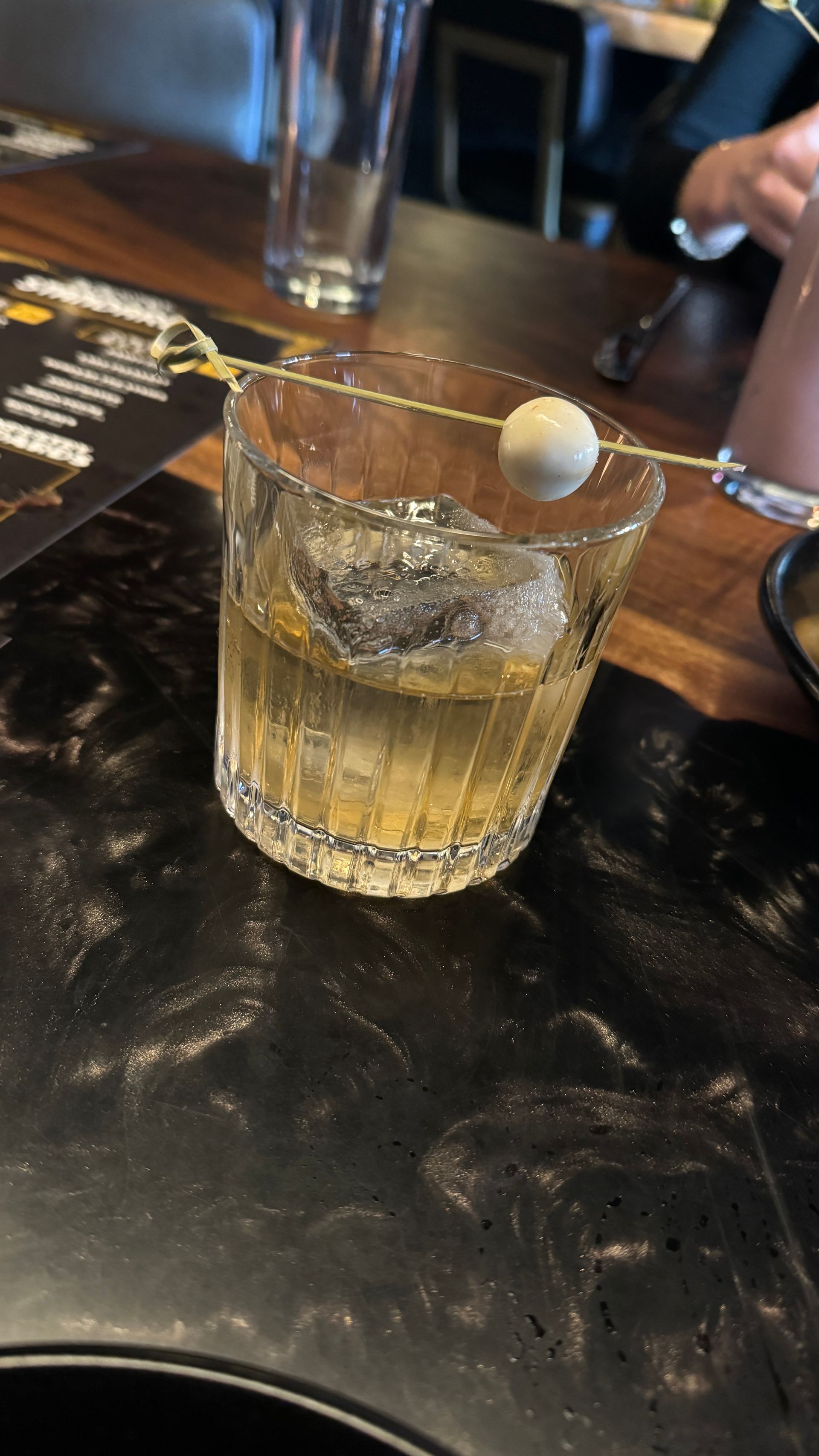A close up of a glass of whiskey on a table.