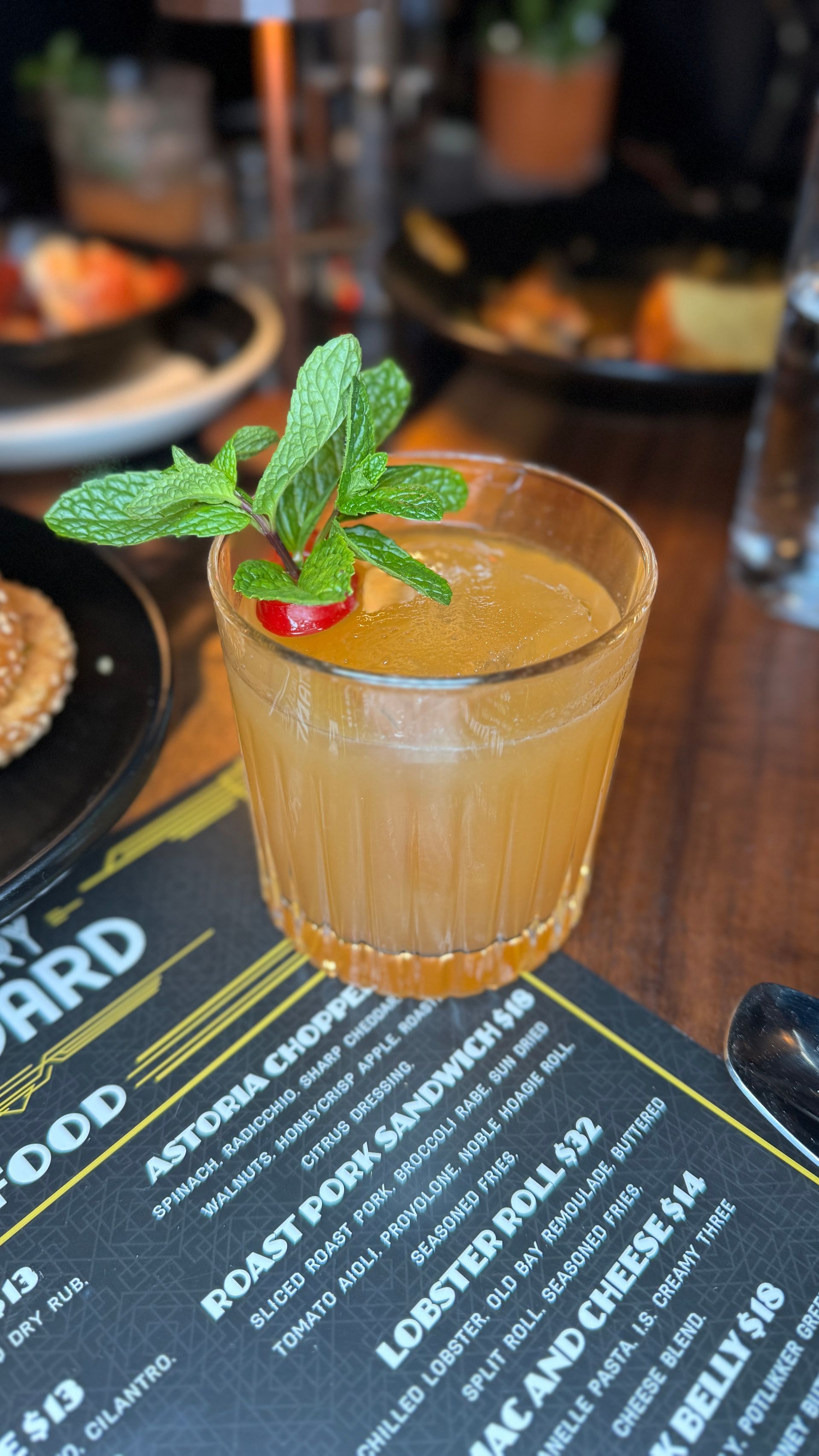A close up of a drink on a table next to a menu.