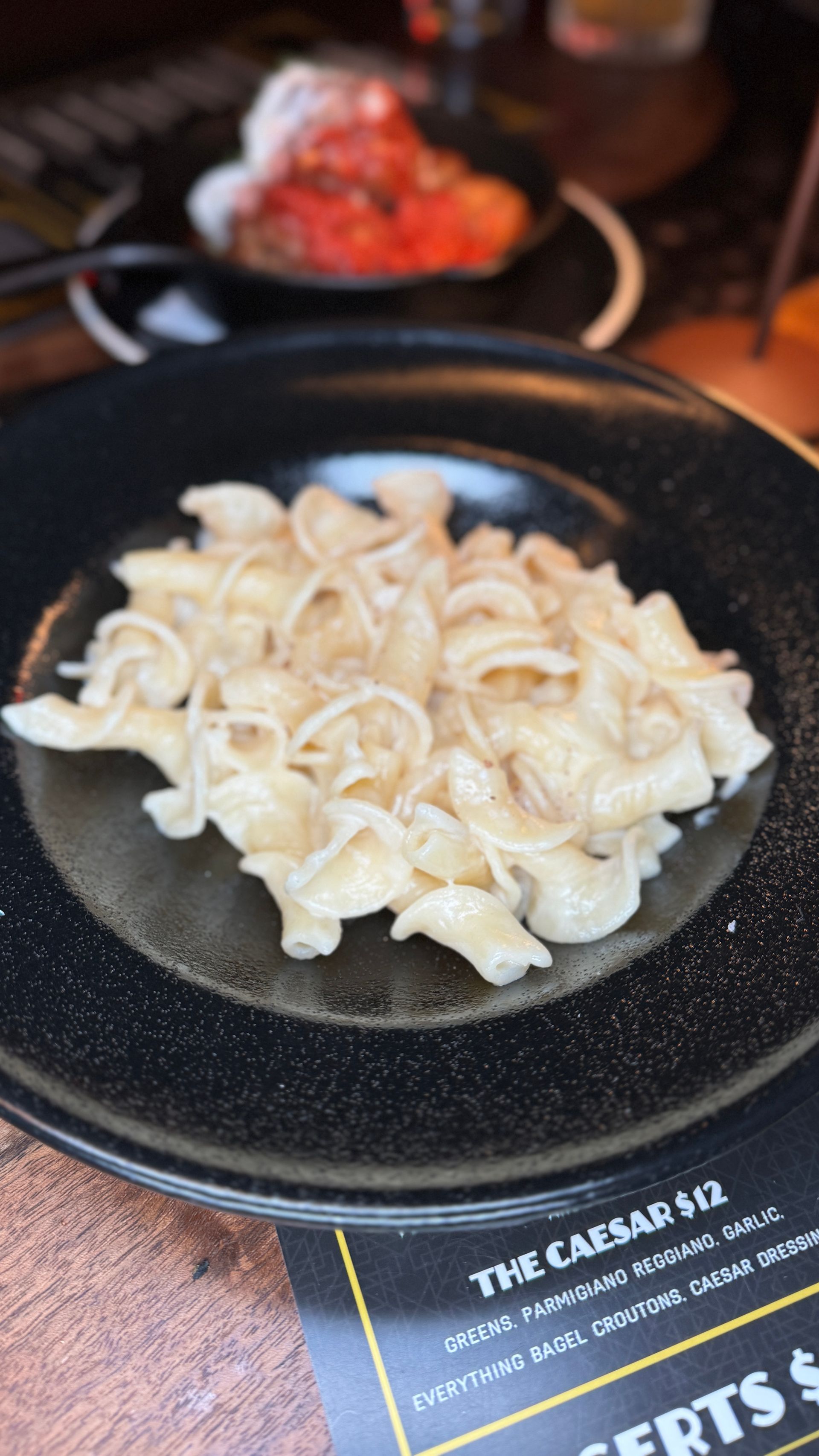 A close up of a plate of pasta on a table.