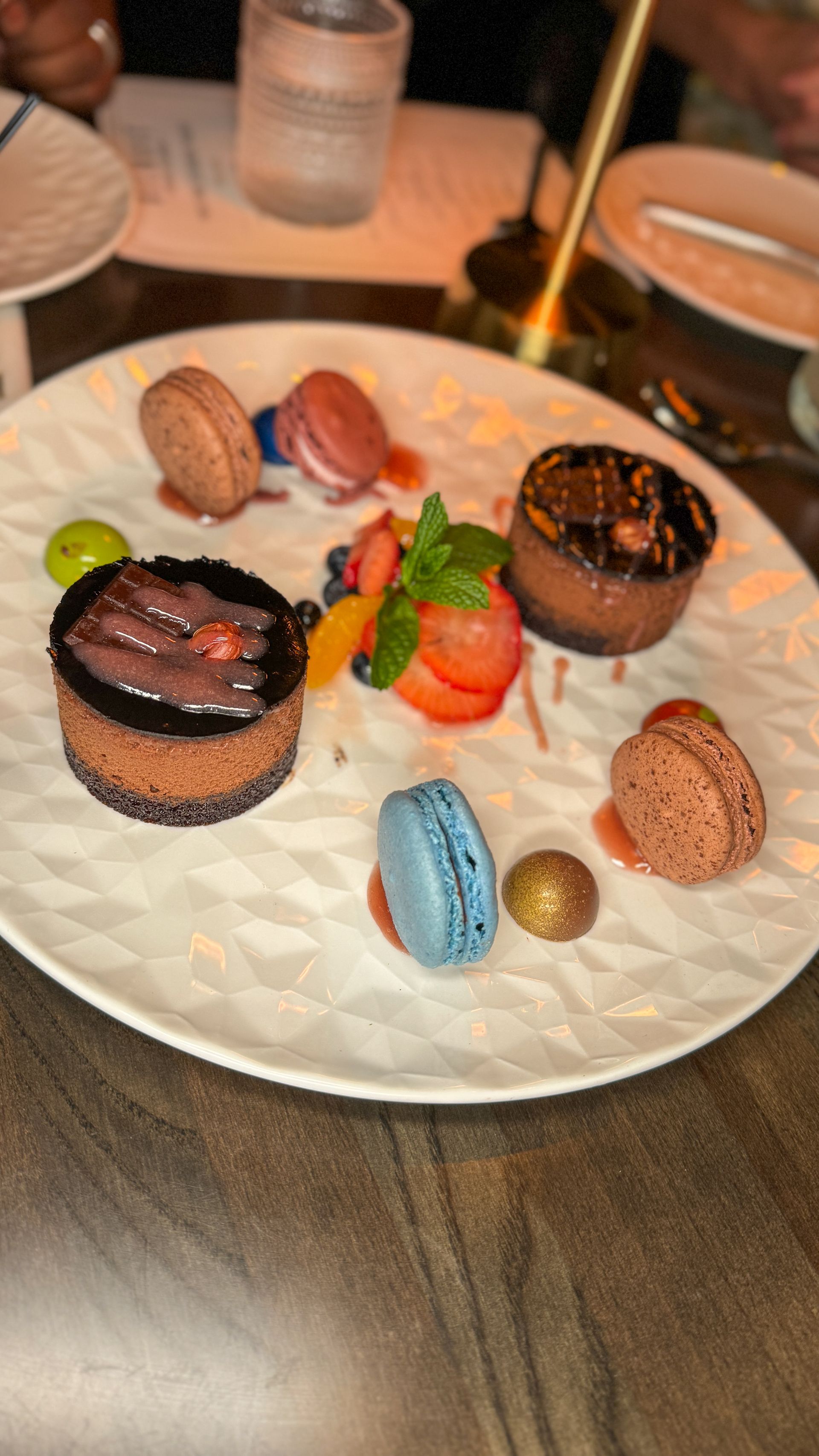 A white plate topped with a variety of desserts on a table.