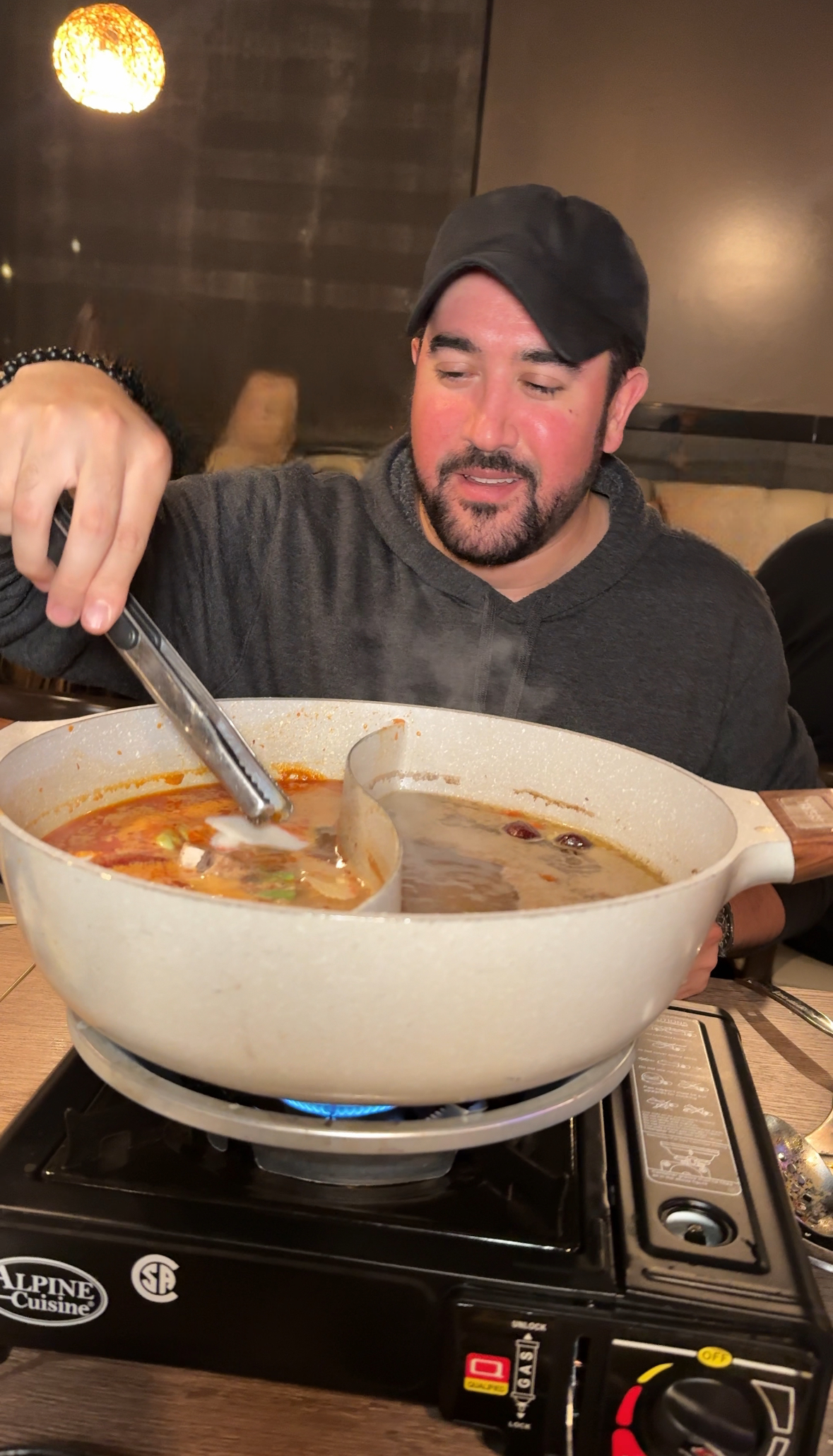 Skyler Paladino stirring a pot of soup on a stove.