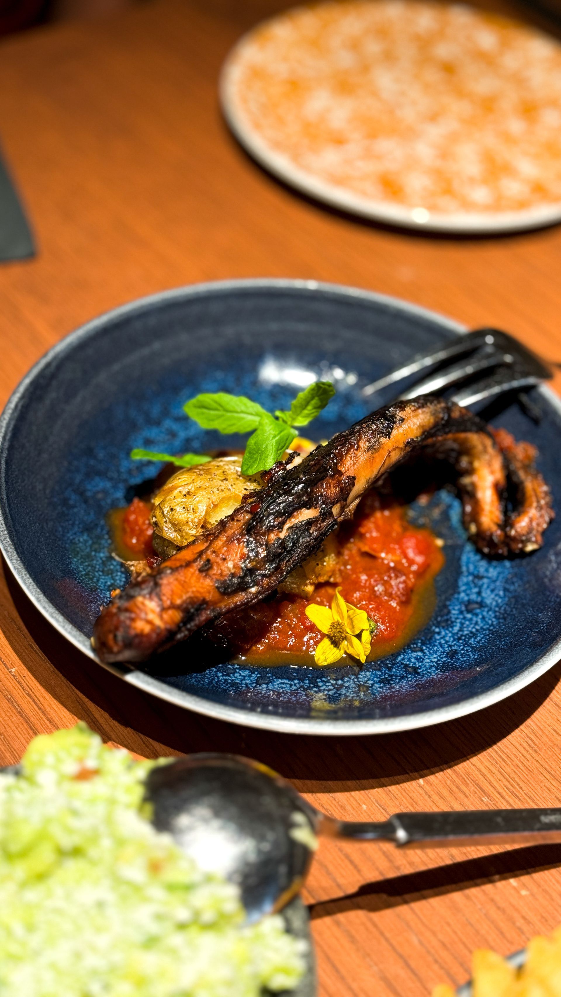 A close up of a plate of food with a fork on a table.