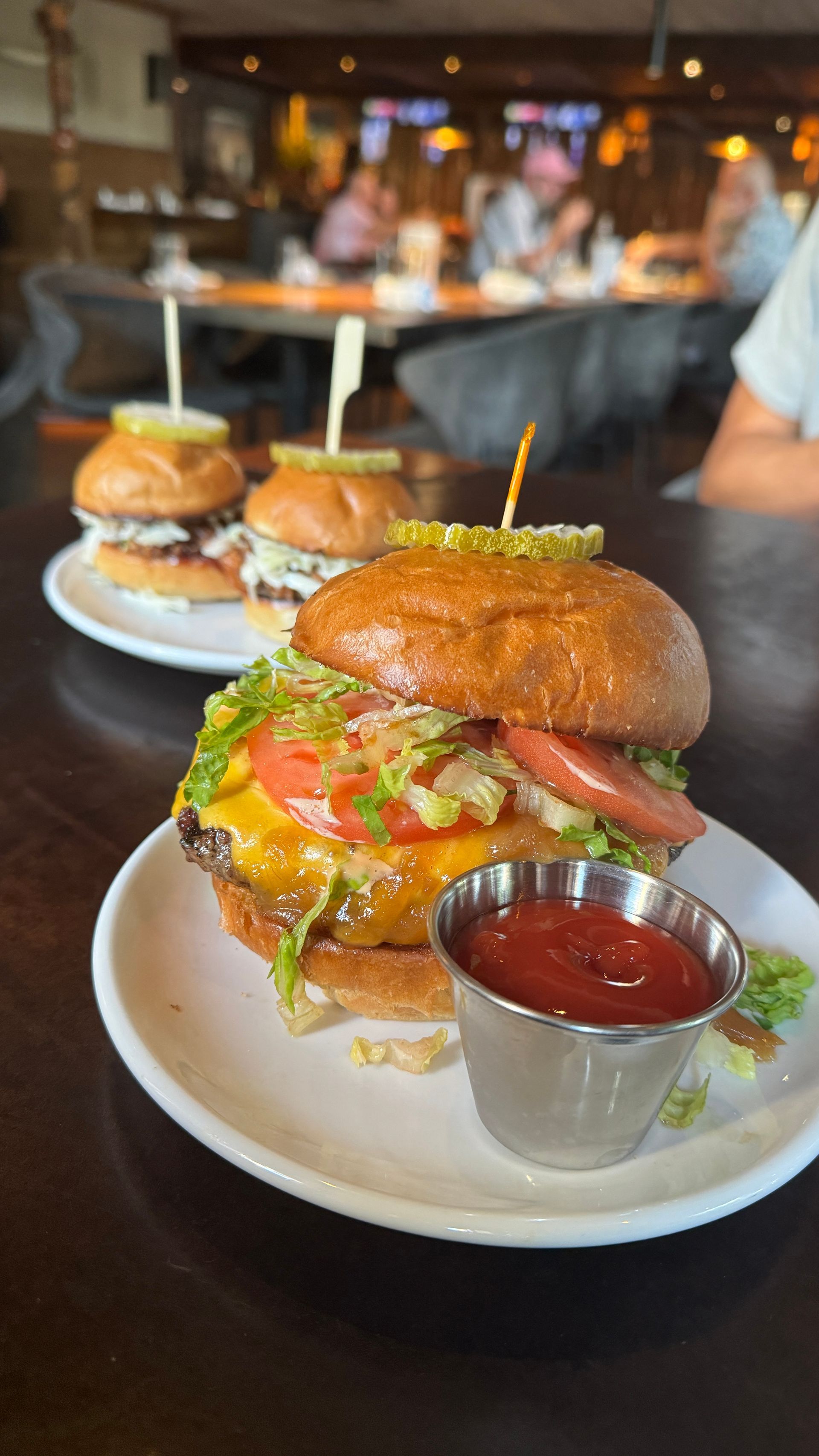 A close up of a hamburger on a plate with ketchup.