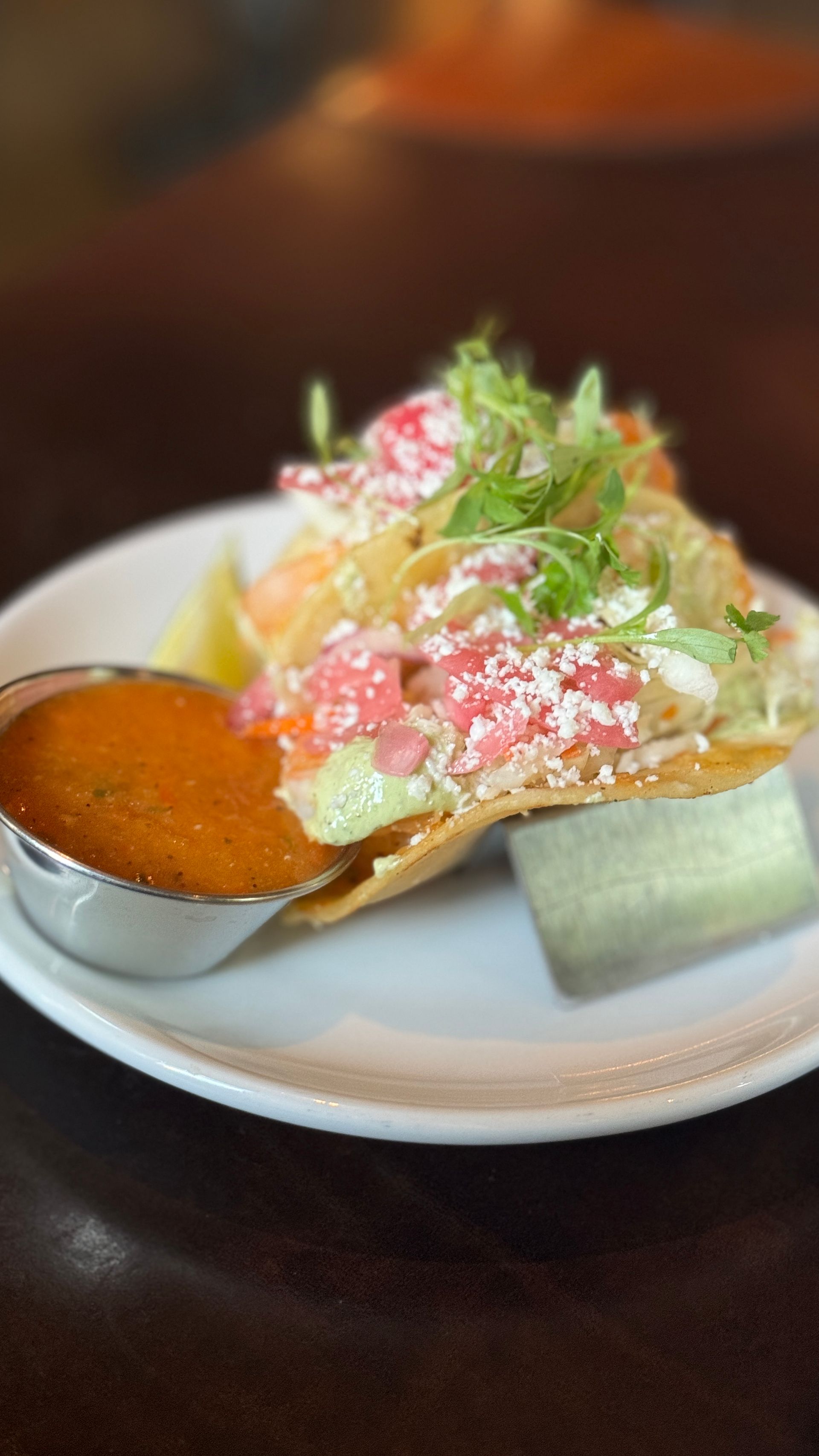 A close up of a plate of food with a dipping sauce on a table.