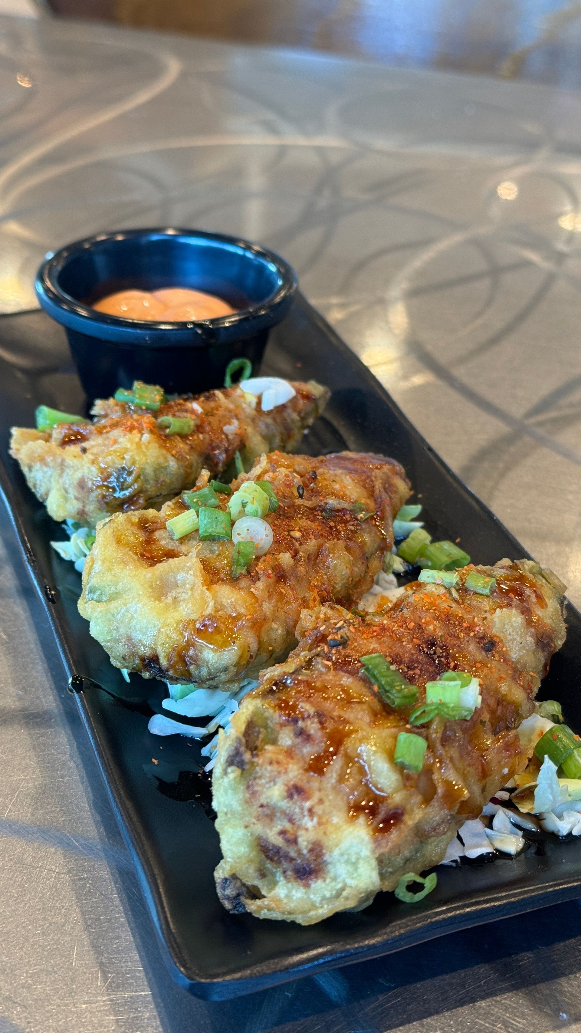 A close up of a plate of food with sauce on a table.