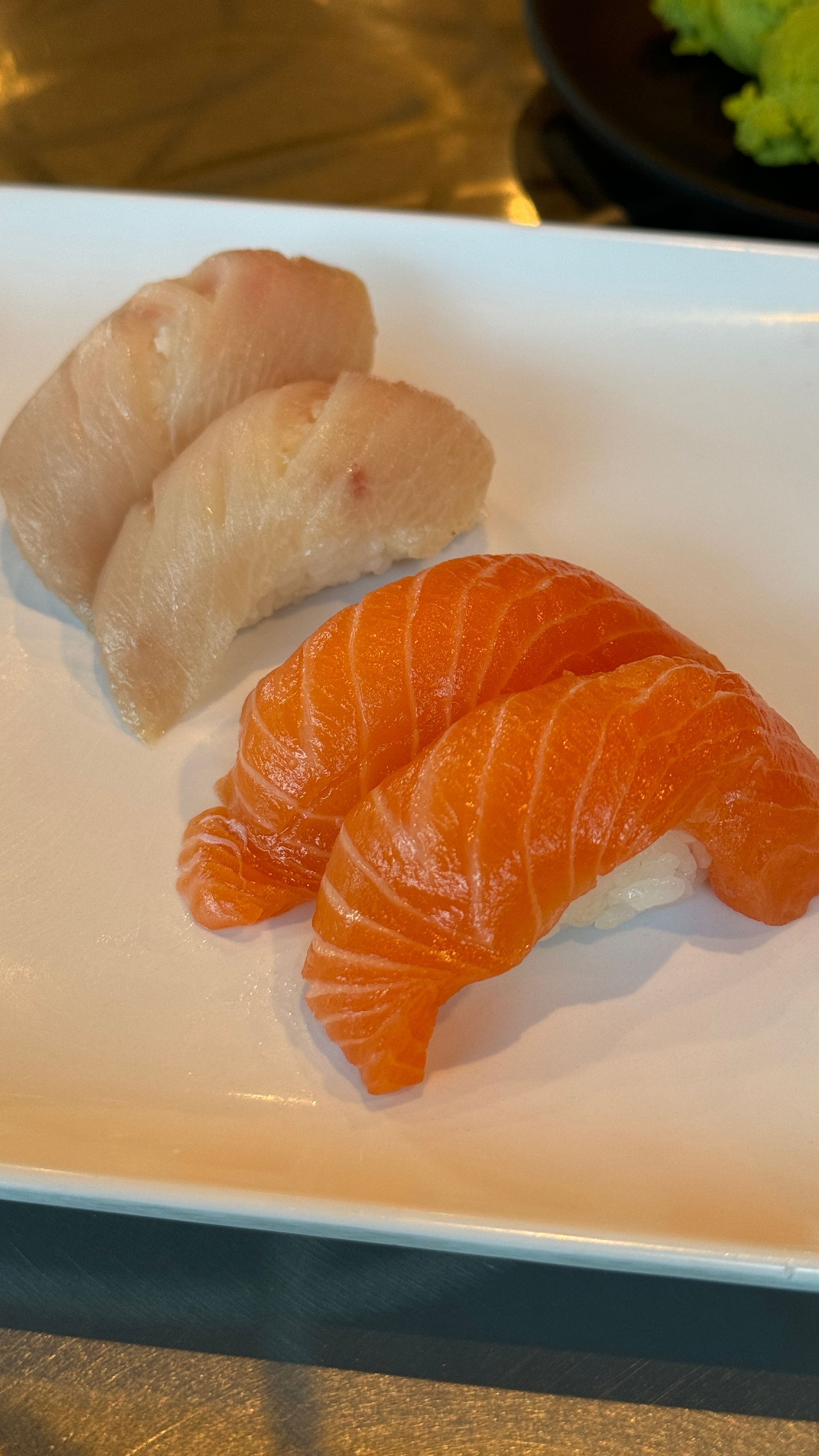 There are two different types of sushi on a white plate.