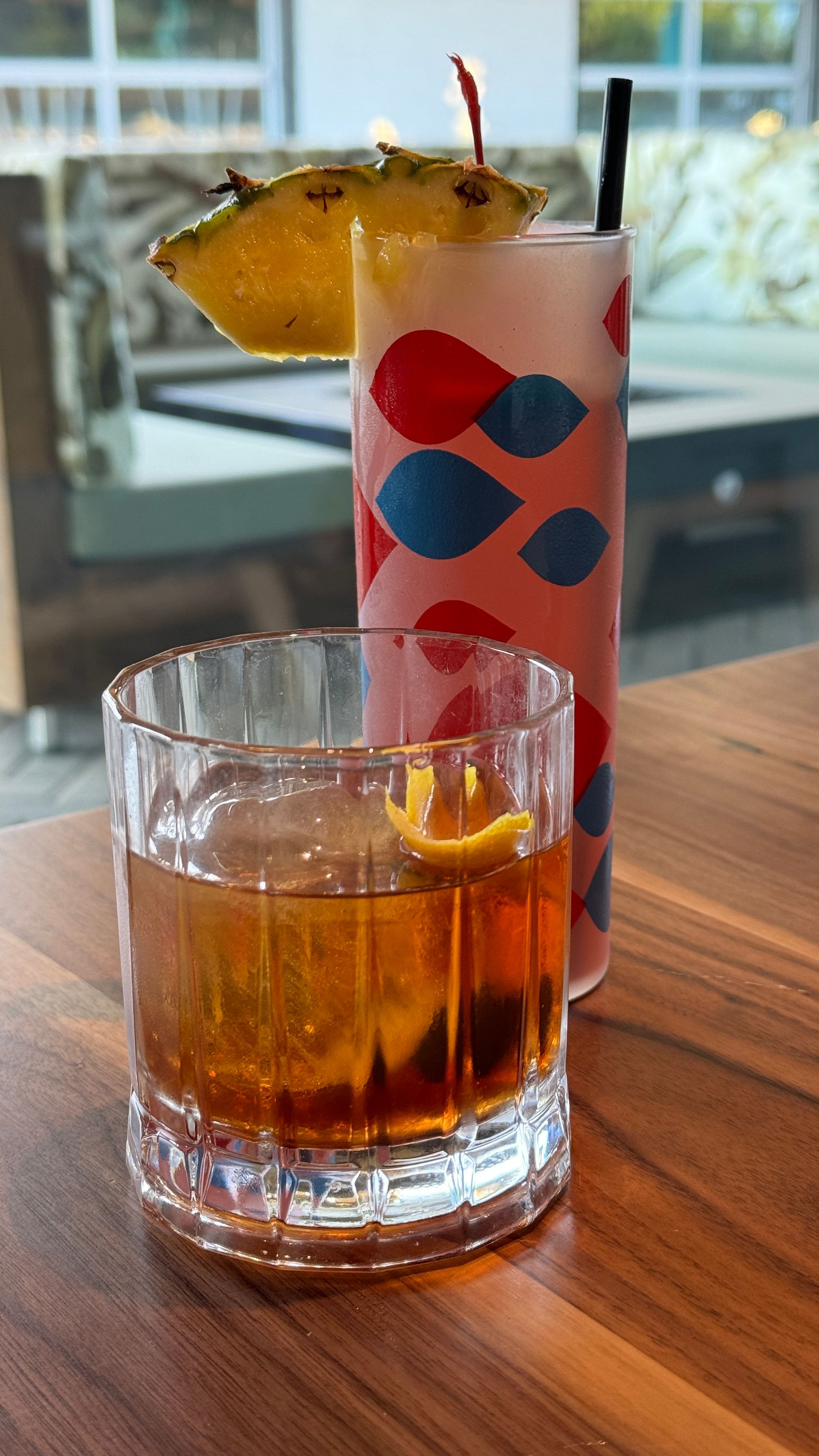 Two drinks are sitting on a wooden table.