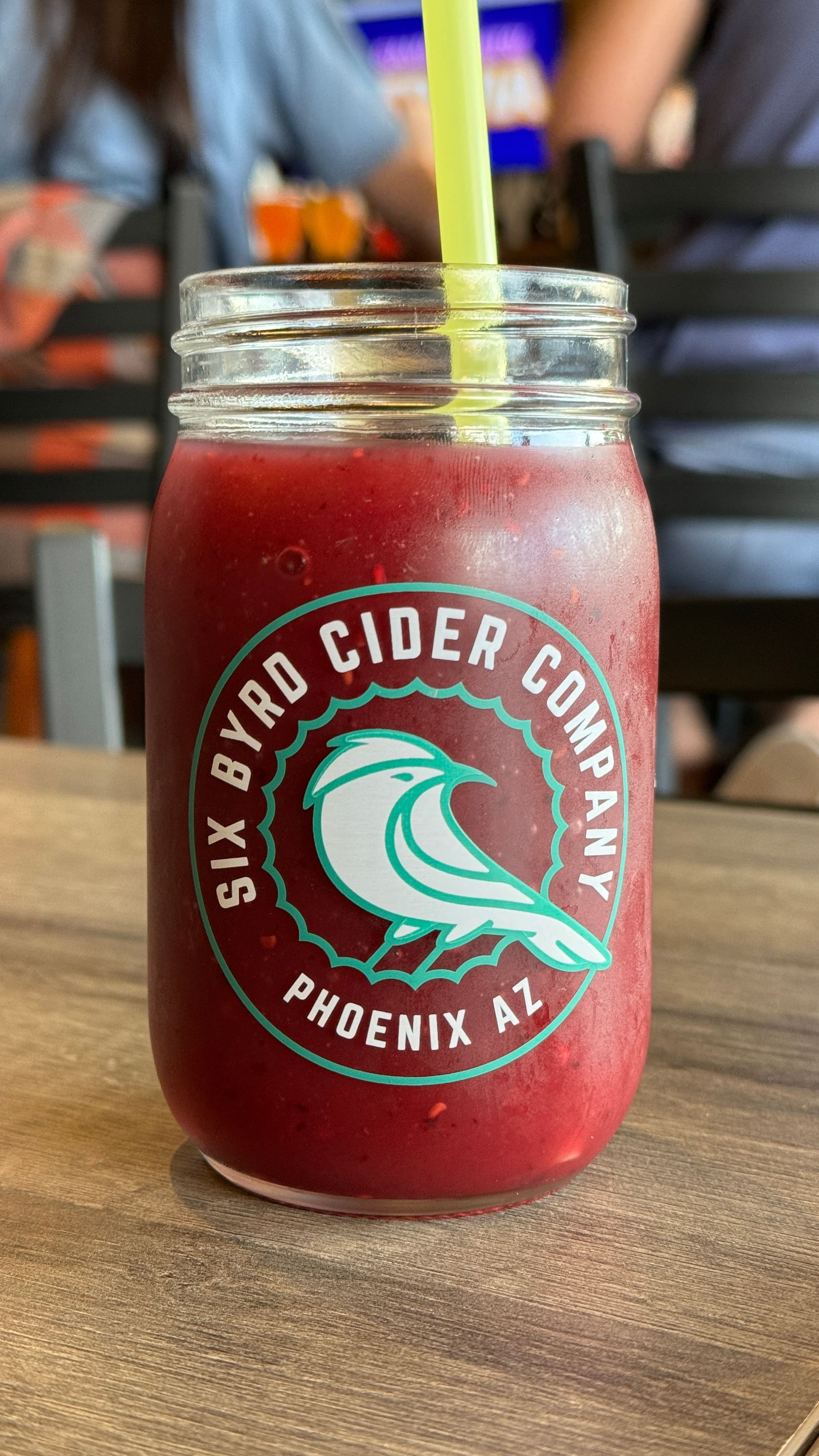 A mason jar filled with a smoothie from the six bird cider company