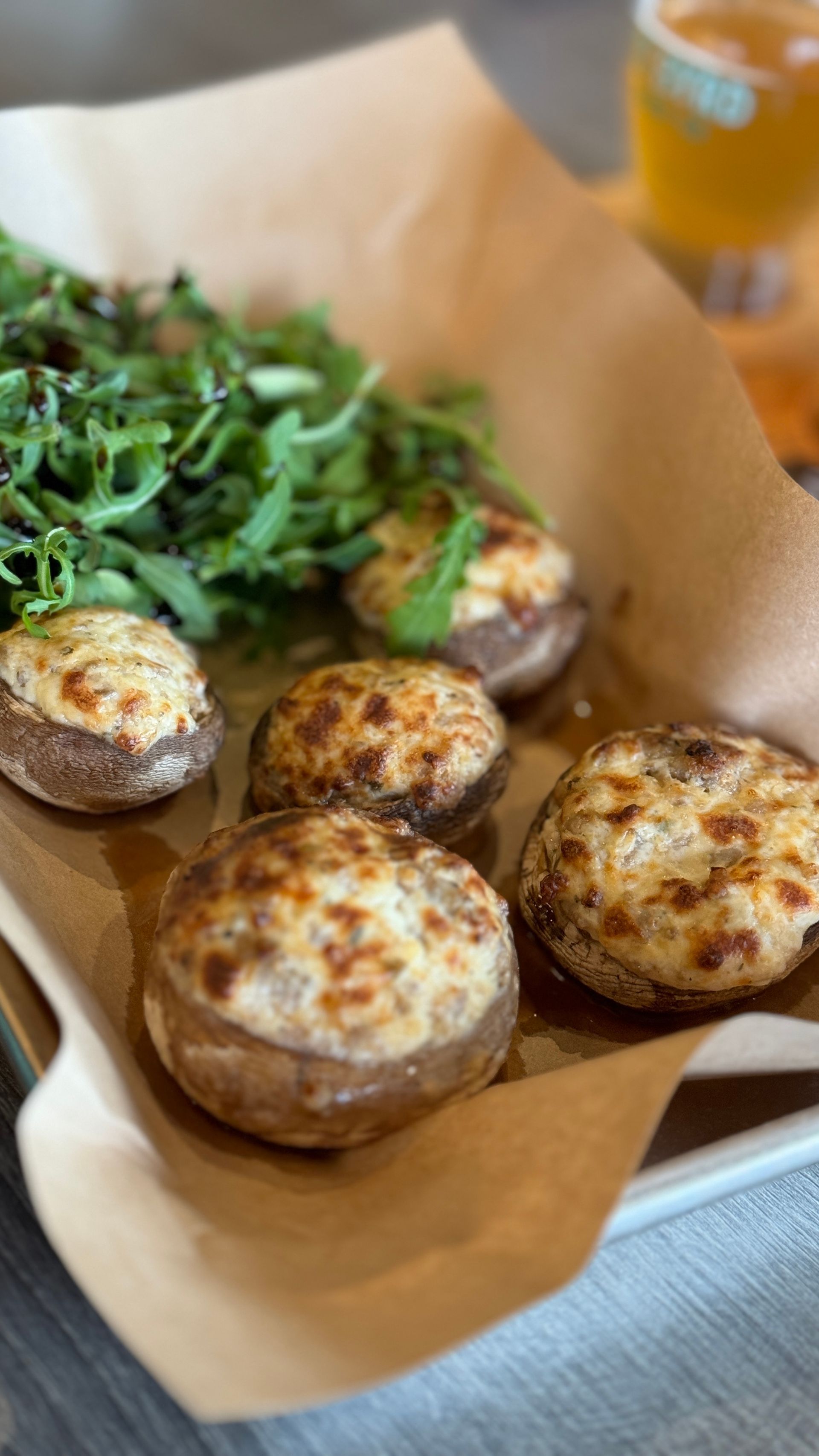 A close up of a plate of stuffed mushrooms on a table.