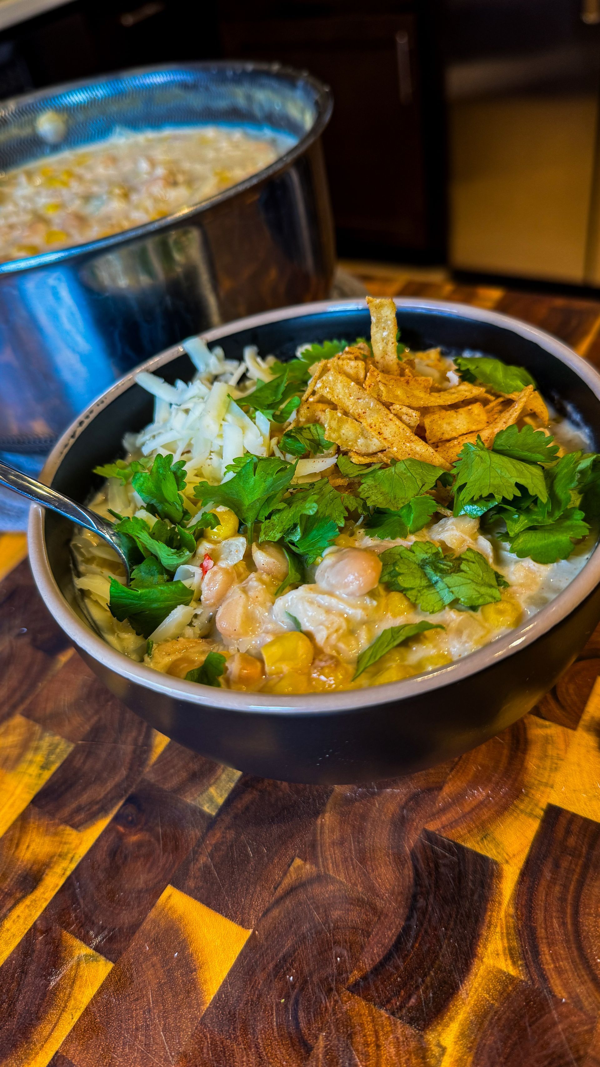 Pot of stew with carrots and meat, served in a black bowl.