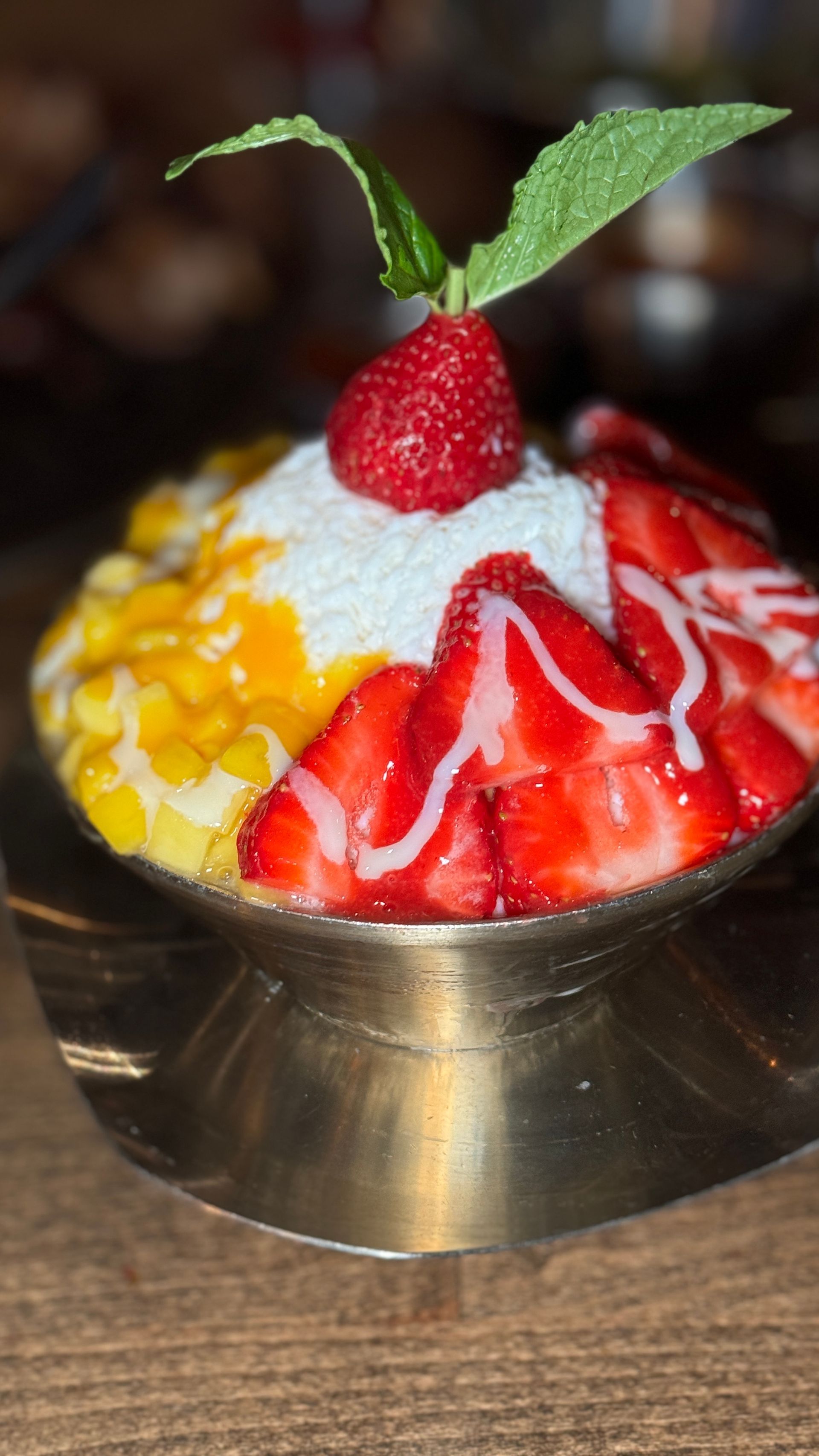 A close up of a bowl of food with strawberries on top.