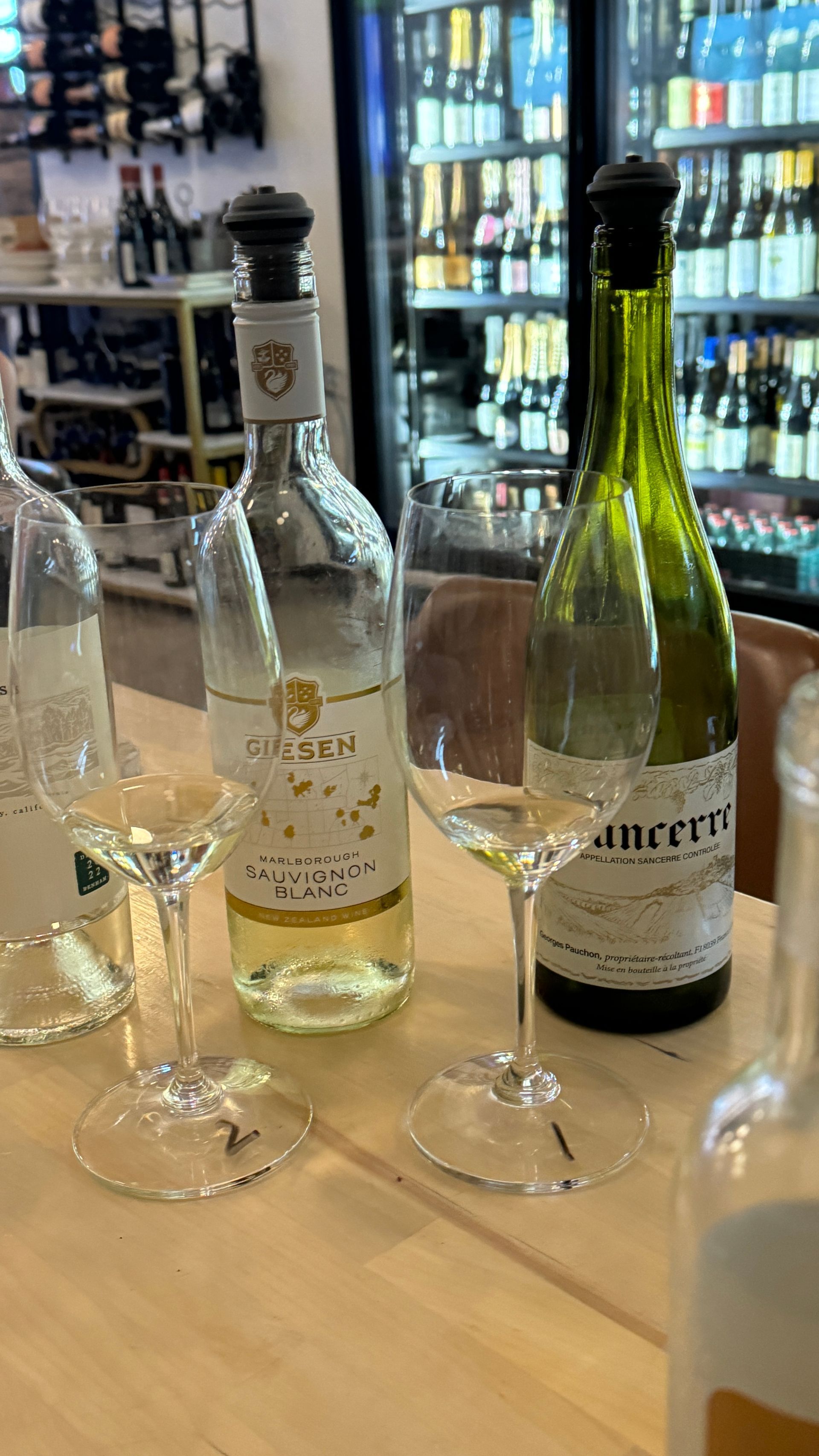 A table with bottles of wine and wine glasses on it.