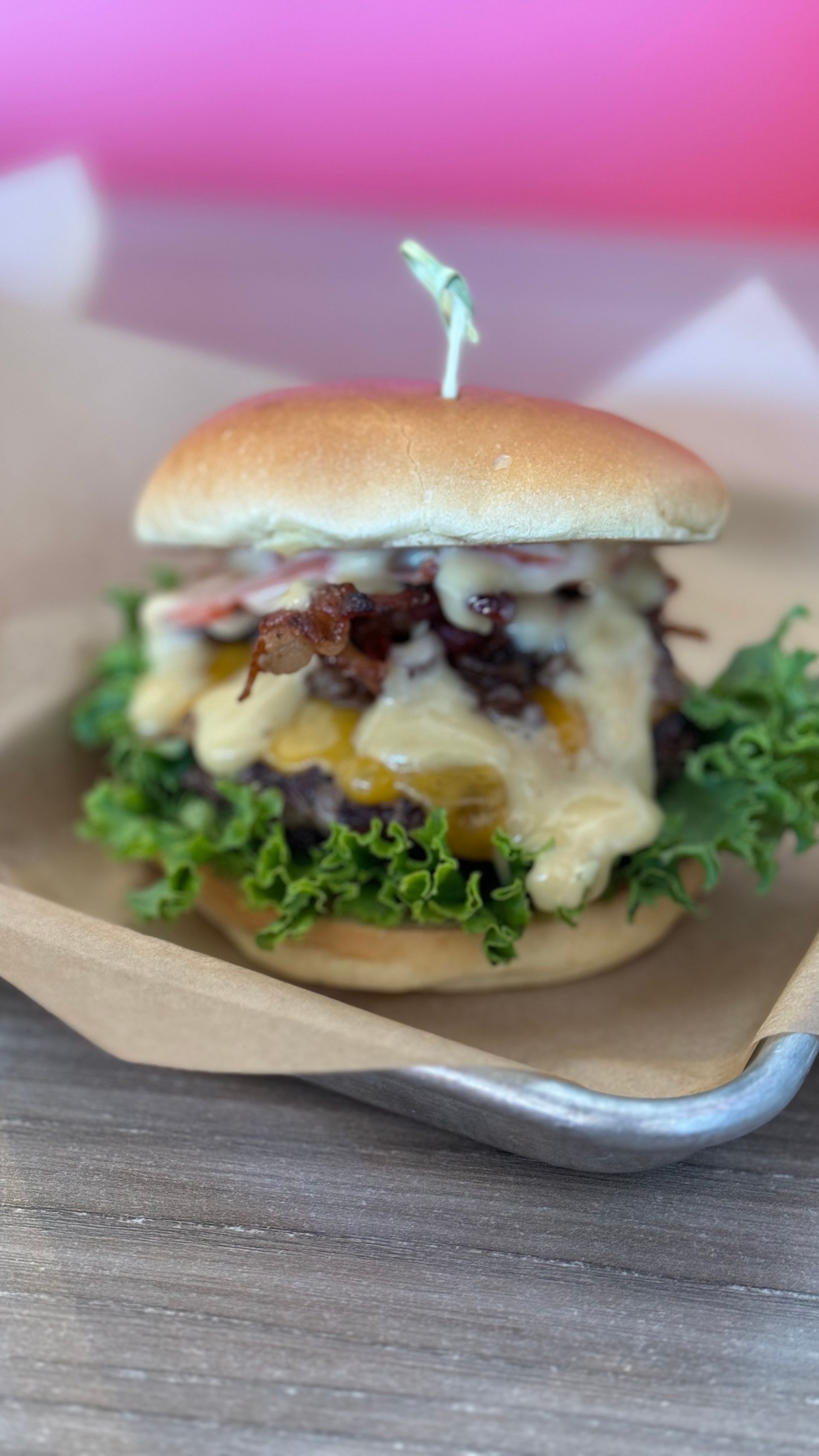 Aioli Gourmet Burgers - A close up of a hamburger on a tray on a table.