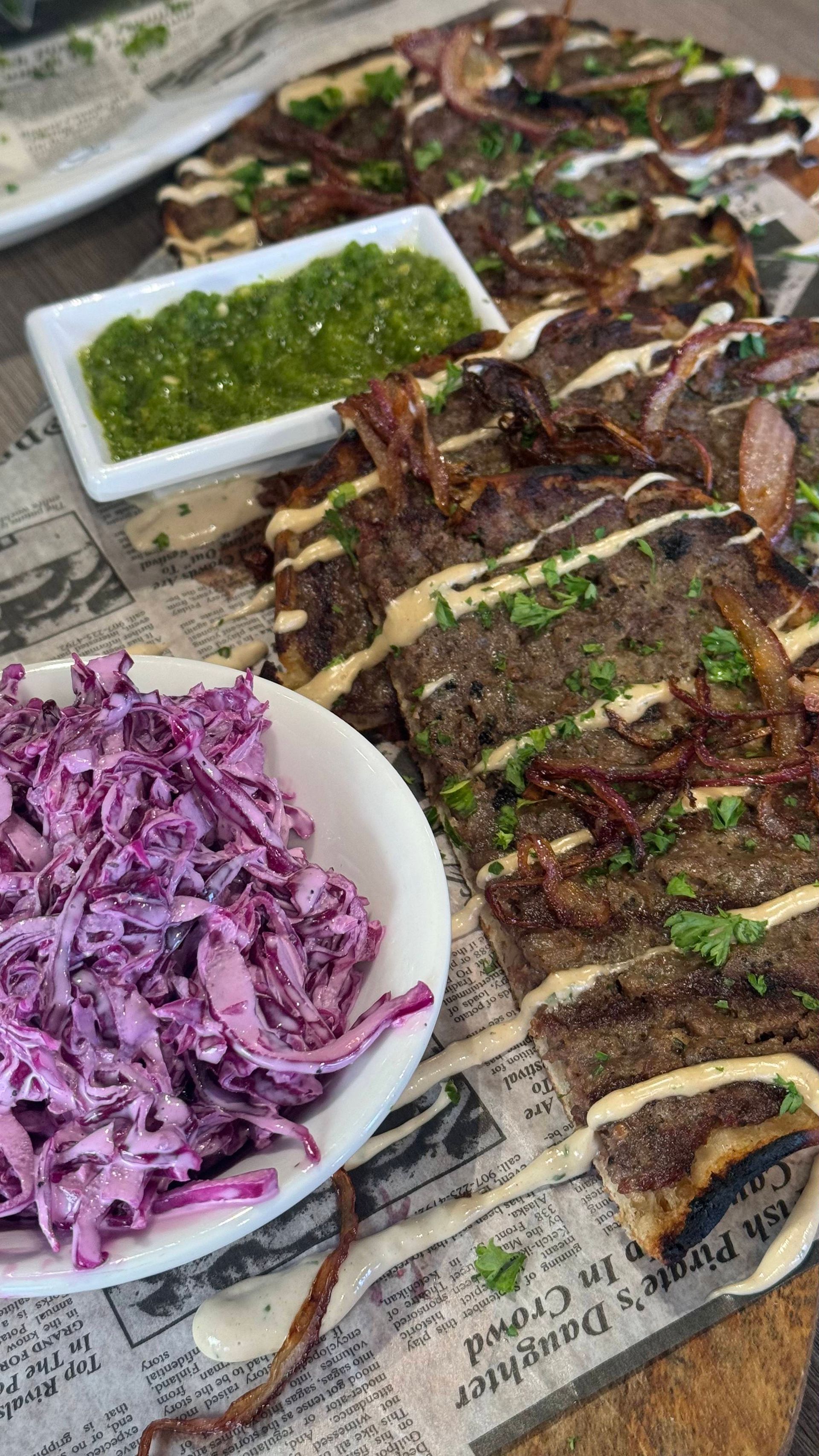Fata Morgana - A plate of coleslaw next to a plate of food on a table.