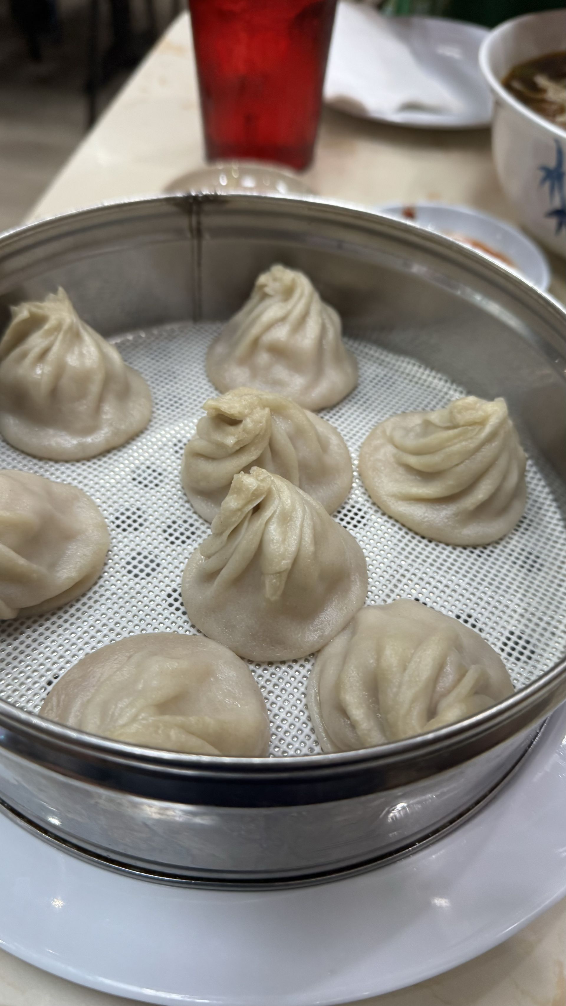 Happy Baos - A bunch of dumplings are sitting in a steamer on a table.
