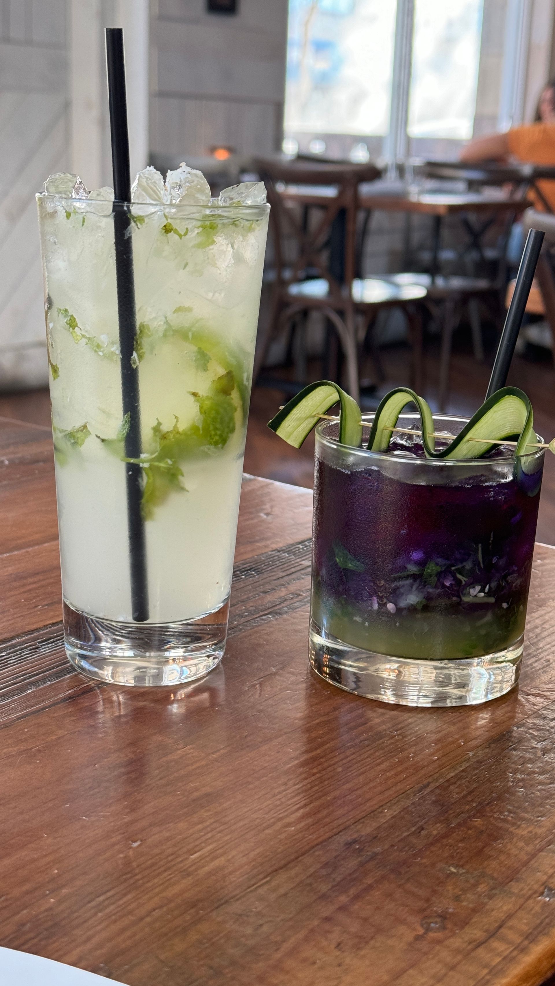 Two drinks are sitting on a wooden table.