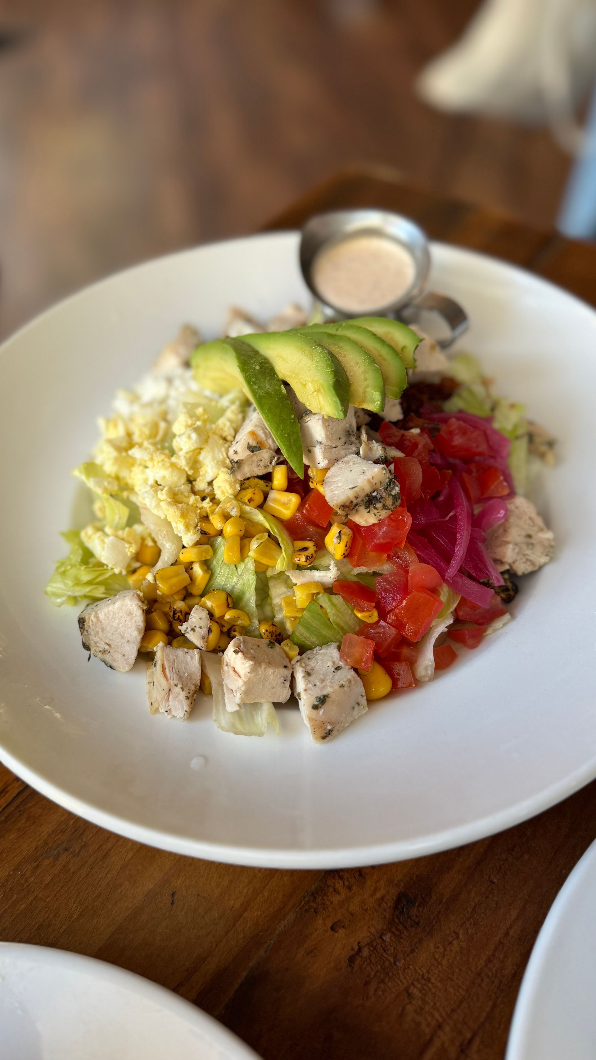 A close up of a salad on a plate on a table.