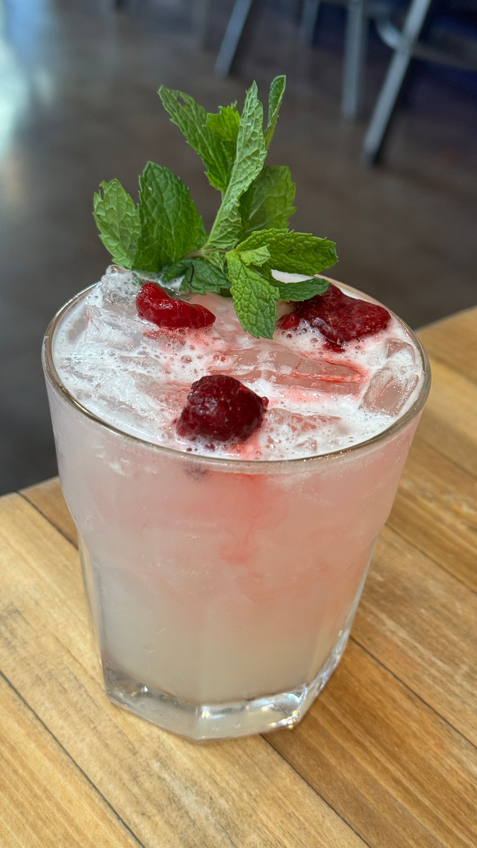 A close up of a drink in a glass on a table.