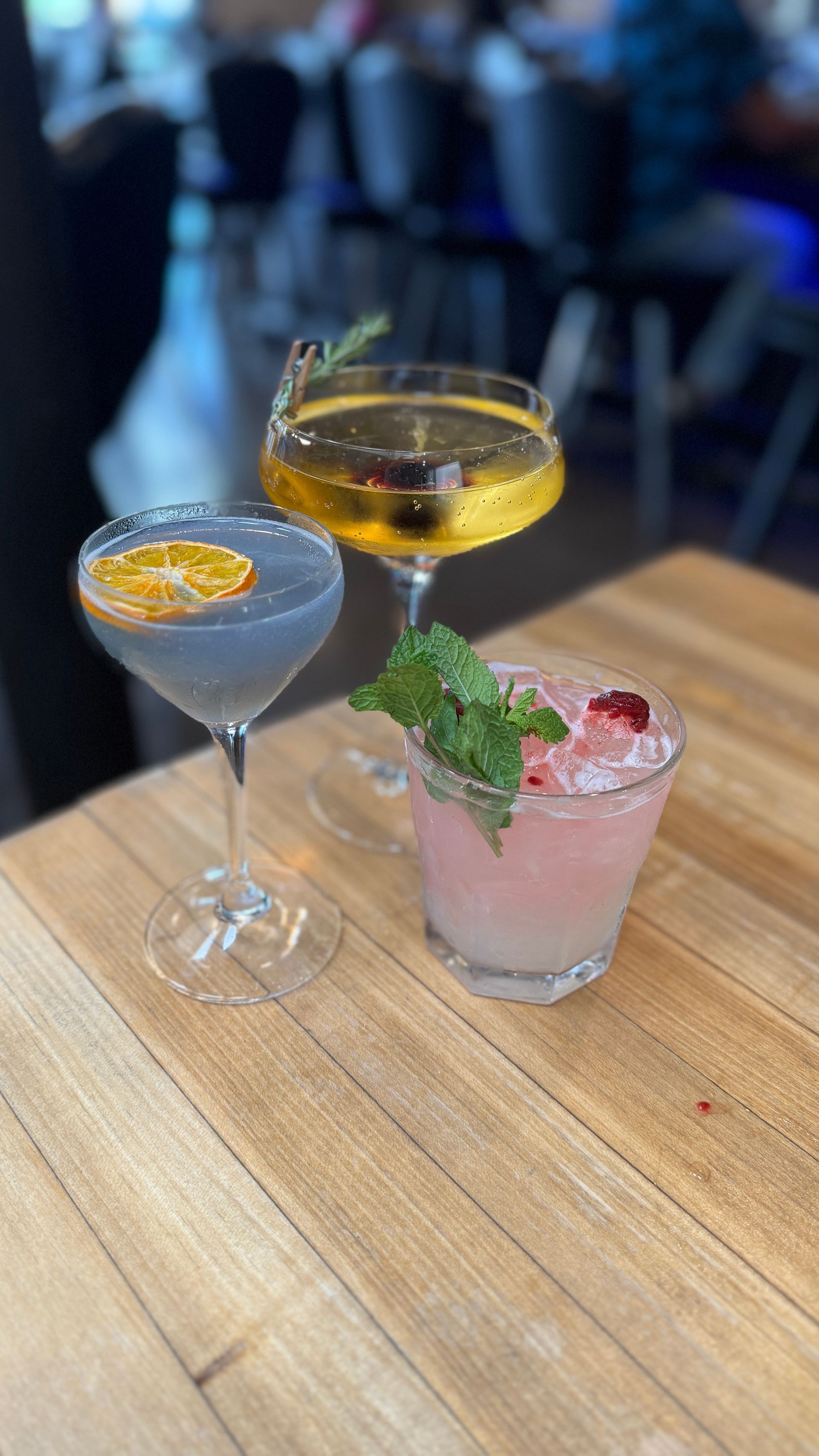 Three different types of drinks are sitting on a wooden table.