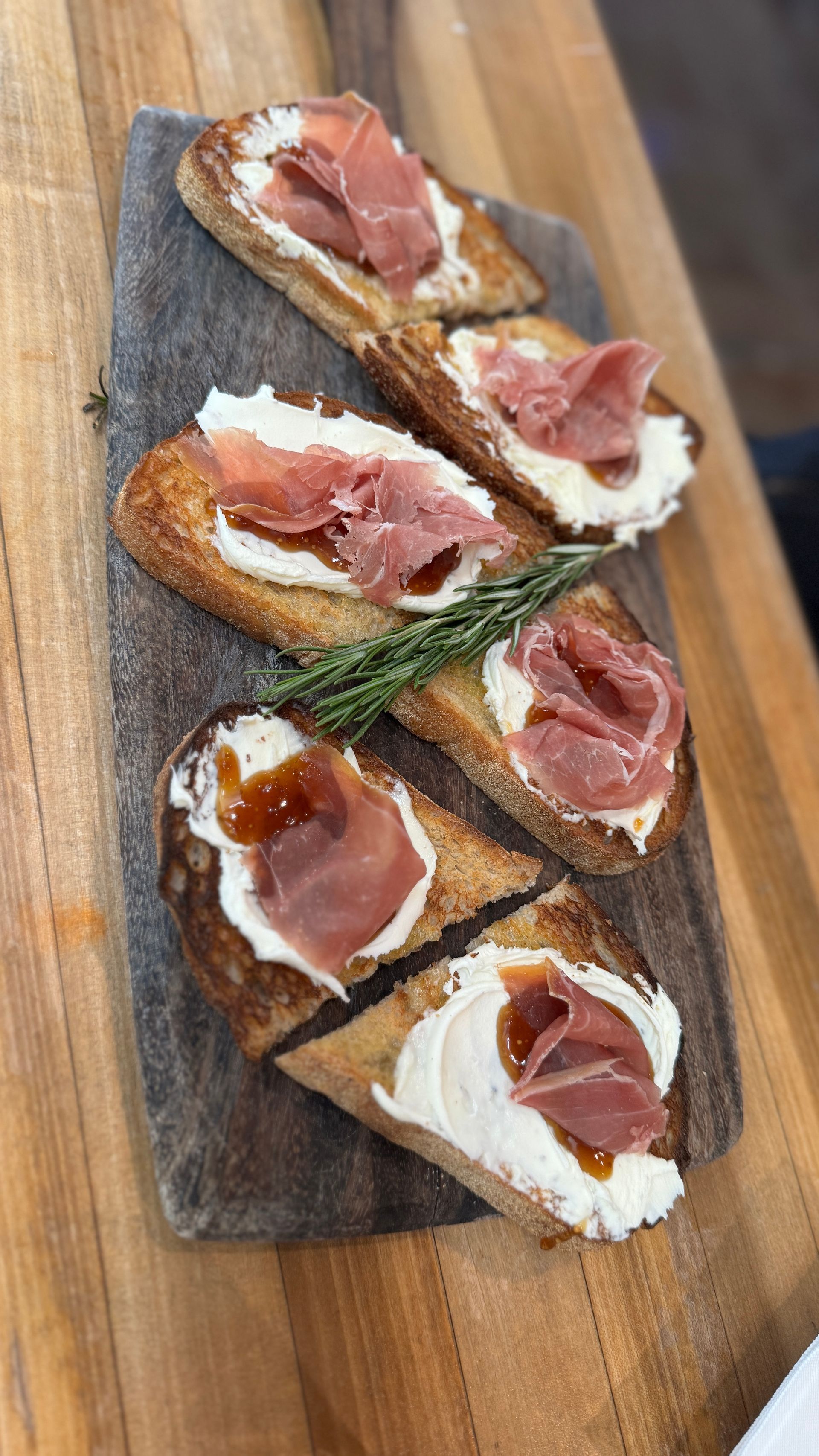 A wooden cutting board topped with sandwiches with ham and cheese.